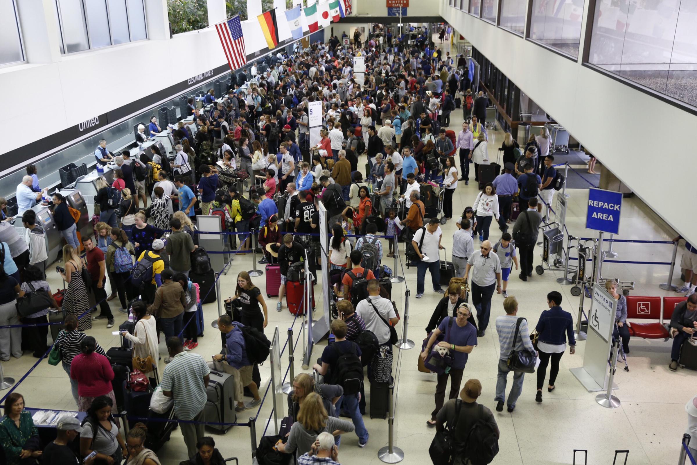 LOS ANGELES, CA JULY 8: Passengers wait in long lines at the United Airlines terminal at LAX in the morning after a nation-wide flight stoppage July 8, 2015 in Los Angeles, California. United Airlines flights are no longer grounded, according to an alert from the Federal Aviation Administration. (Photo by Al Seib/Los Angeles Times via Getty Images)