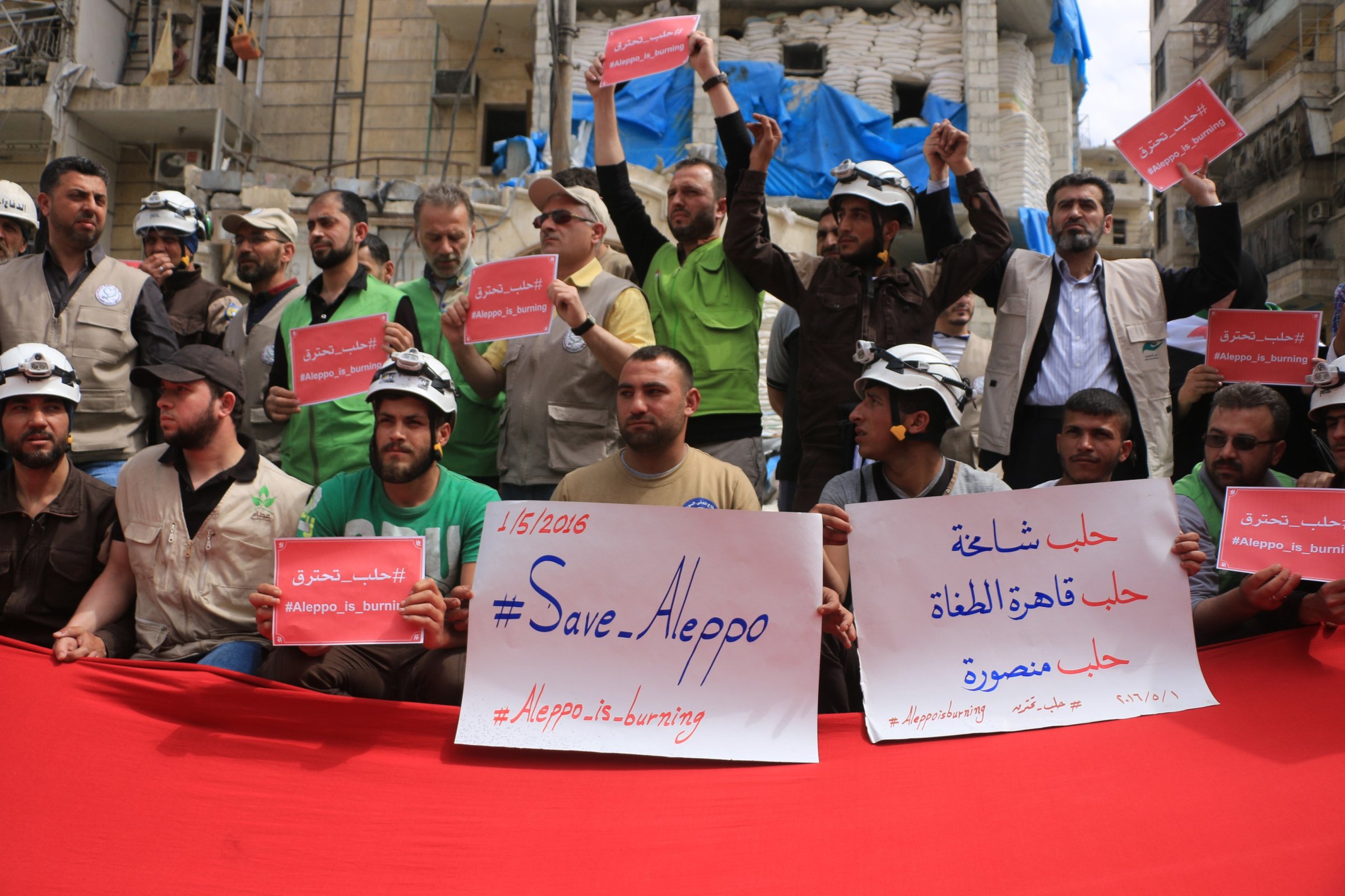 Syrians hold banners during a protest against Russian airstrikes on Jerusalem field hospital in the Sukkeri neighborhood of Aleppo, Syria, on May 1, 2016.