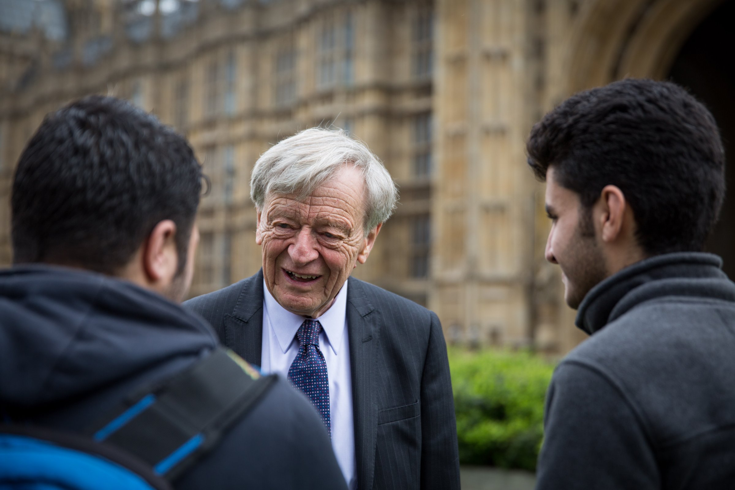 Lord Alf Dubs speaks to two child refugees from Syria on College Green on April 25, 2016 in London, England.
