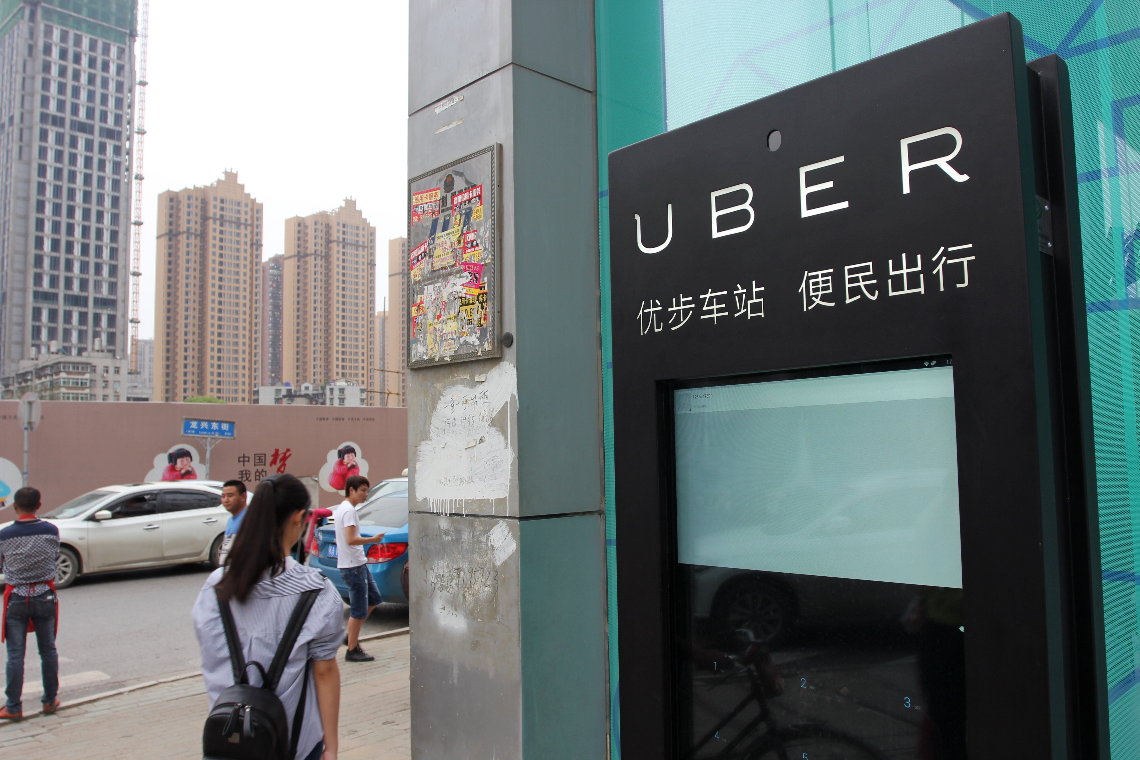 A pedestrian walks past a service station of Uber in Wuhan, China, April 14, 2016 (Sun xinming—Imaginechina/Getty Images)