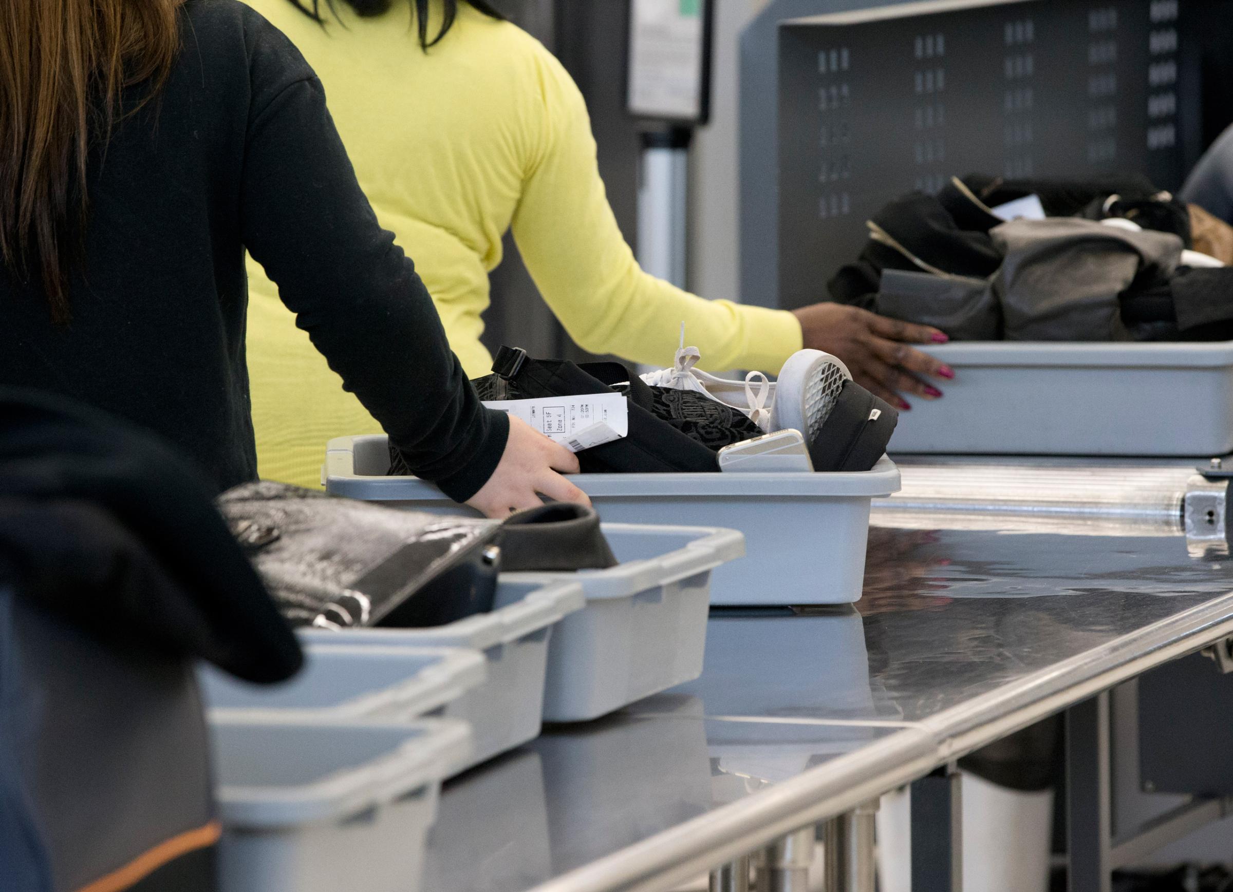 Passengers load their items into bins to be scanned as they pass through security at the Fort Lauderdale-Hollywood International Airport, Friday, Dec. 18, 2015, in Fort Lauderdale, Fla. Transportation Security Administration spokesperson Sari Koshetz said that about 8,000 lbs. of prohibited items were confiscated this year by the TSA at the Fort Lauderdale airport. (AP Photo/Wilfredo Lee)