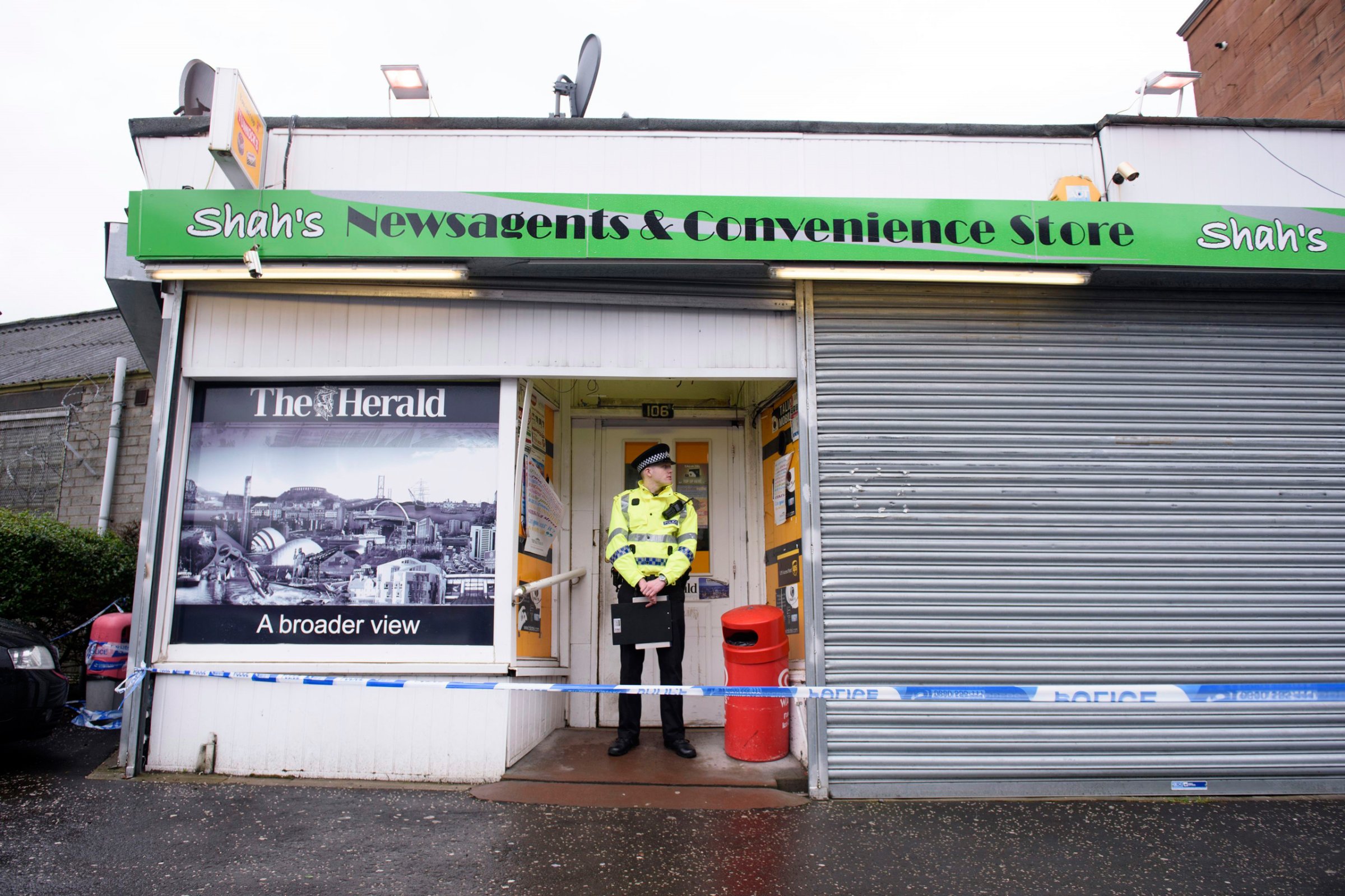 A police officer stands outside the shop where Asad Shah worked in Glasgow, Saturday March 26, 2016. Scottish police say the killing of a Muslim shopkeeper who wished Christians a happy Easter is being investigated as “religiously prejudiced.” Vigils were held Friday and Saturday in memory of 40-year-old Asad Shah, who was killed Thursday night in Glasgow. (John Linton/PA via AP) UNITED KINGDOM OUT NO SALES NO ARCHIVE