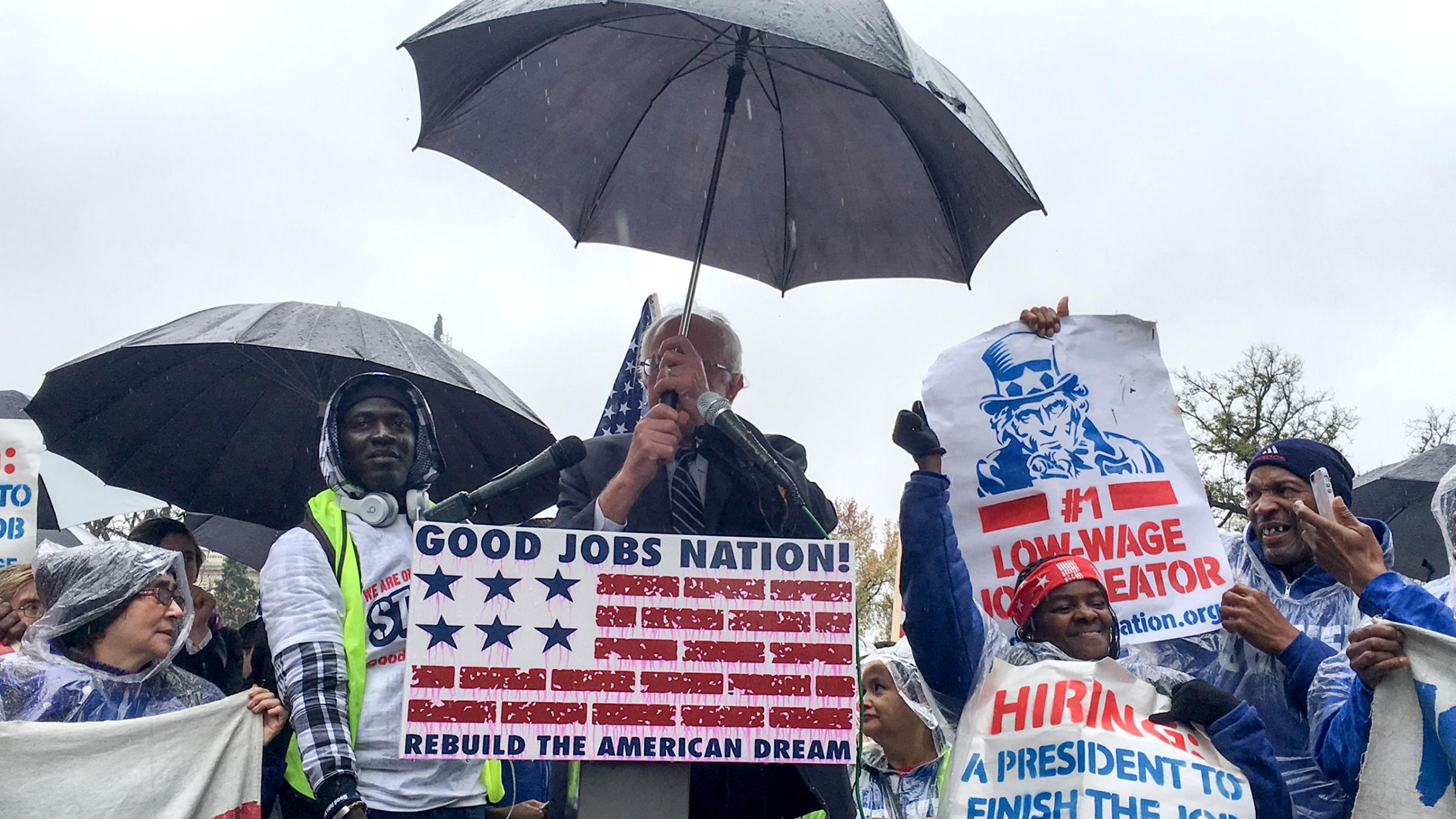 Sen. Bernie Sanders adjusts his umbrella before speaking out in favor of raising the minimum wage in Washington, D.C., Nov.11, 2015.