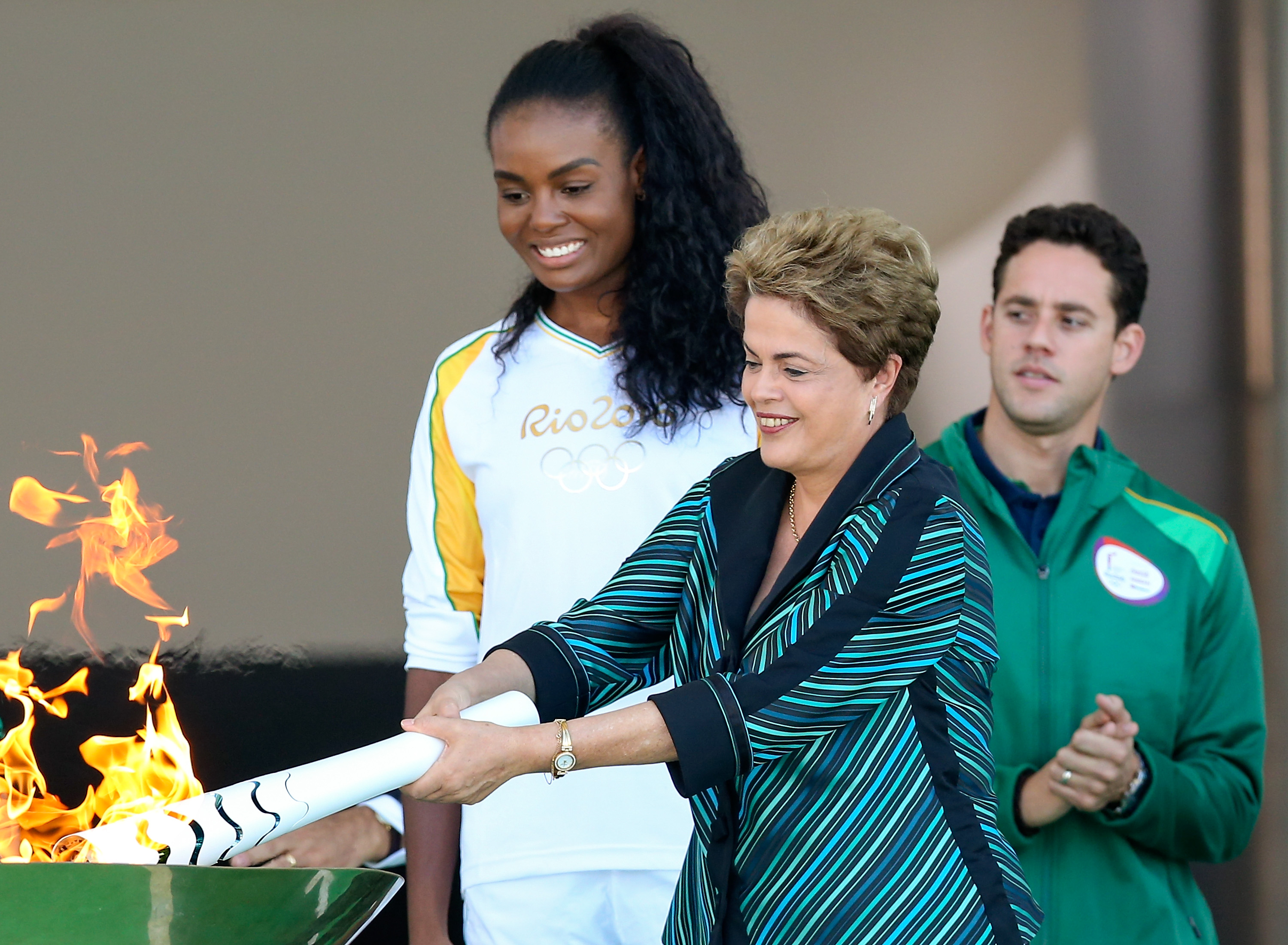 Dilma Rousseff, President of Brazil, lights the Olympic torch with the first torch bearer, volleyball player Fabiana Claudino at the Palacio do Planalto on May 3, 2016 in Brasilia, Brazil. (Buda Mendes—Getty Images)