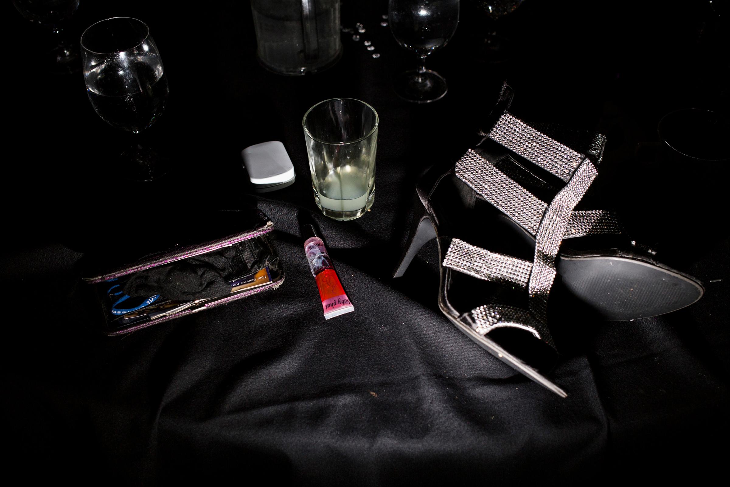 A wallet, lip gloss and shoes lay on a table as students dance at their prom, May 2015.