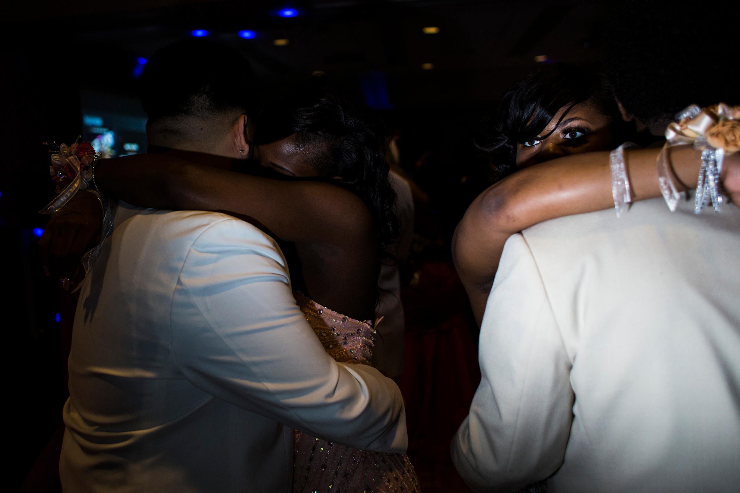 A Flint Southwestern Classical Academy student peers over her prom date's shoulder during a slow dance at the University of Michigan-Flint campus in downtown Flint, May 7, 2016. The theme was "Masquerade."