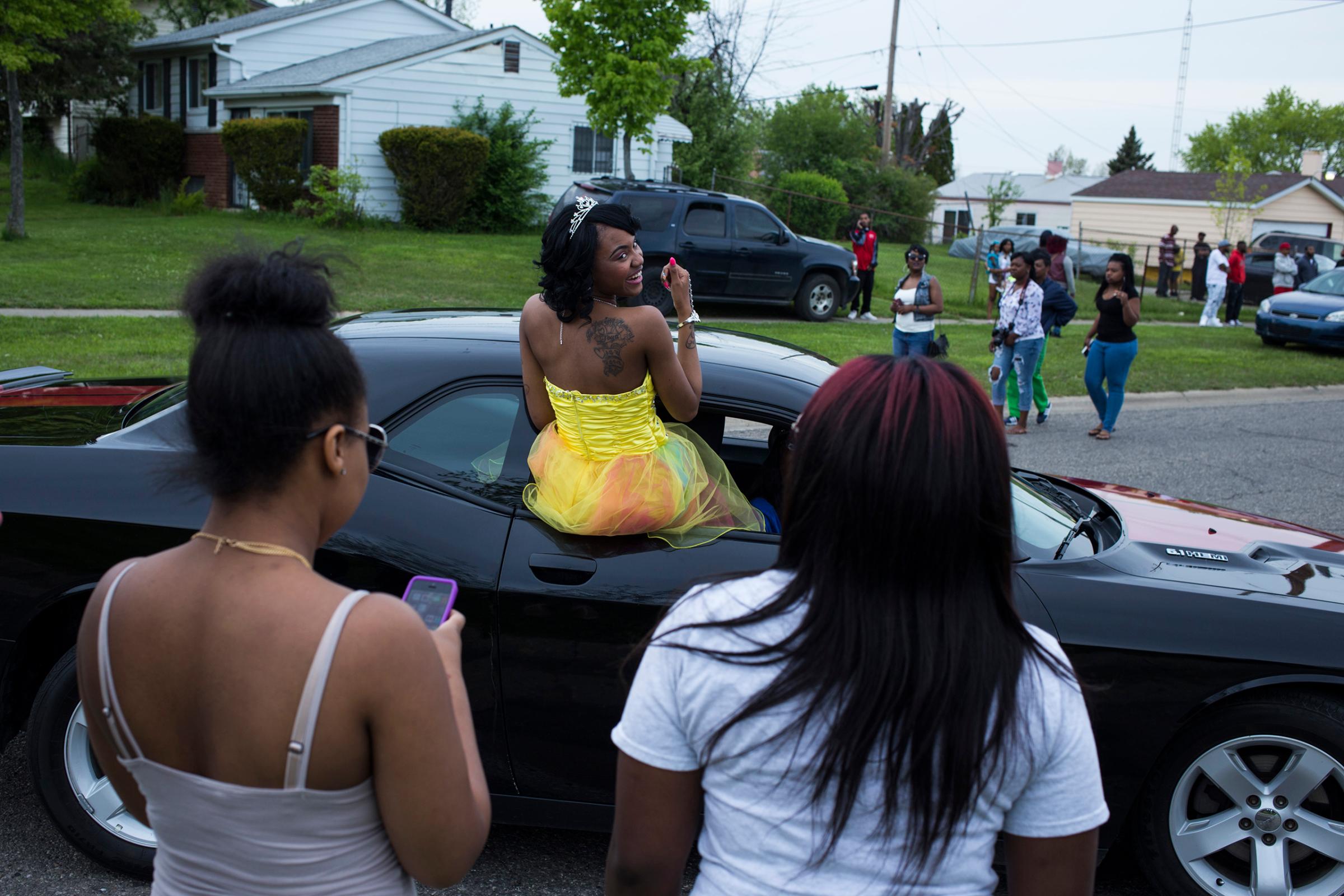 Beecher High School student Chatara Cornelius, 18, of Flint, Mich., dances from the window of a car as she makes her entry during a pre-prom red carpet-style event at Dailey Elementary School in Mount Morris, May 20, 2016.