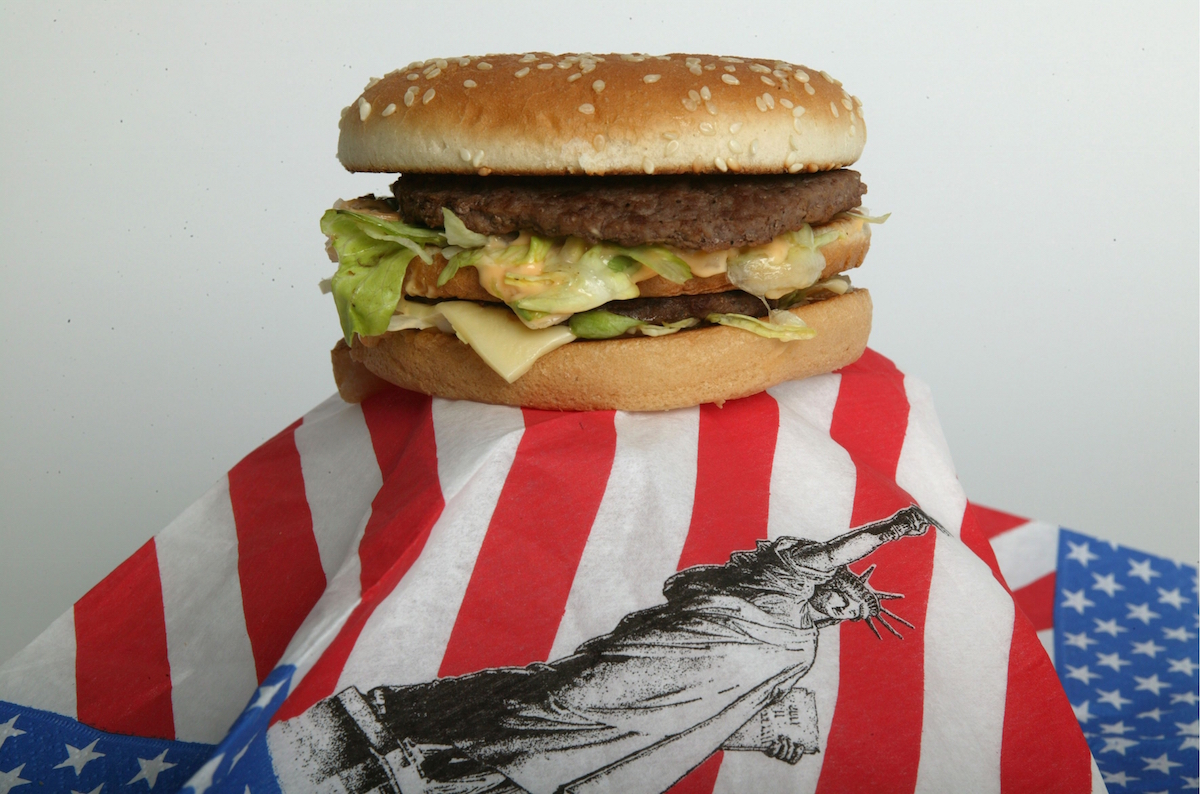 Hamburger ( Big Mac from Mc Donalds ) on an American flag, Feature: fastfood, American fastfood,,.