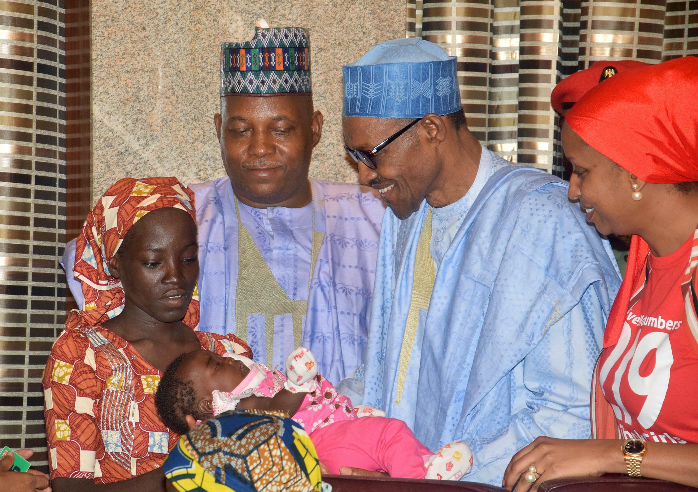 Nigerian President Muhammadu Buhari, second right, receives Amina Ali, the first rescued Chibok school girl, at the Presidential palace in Abuja, Nigeria, May. 19, 2016.