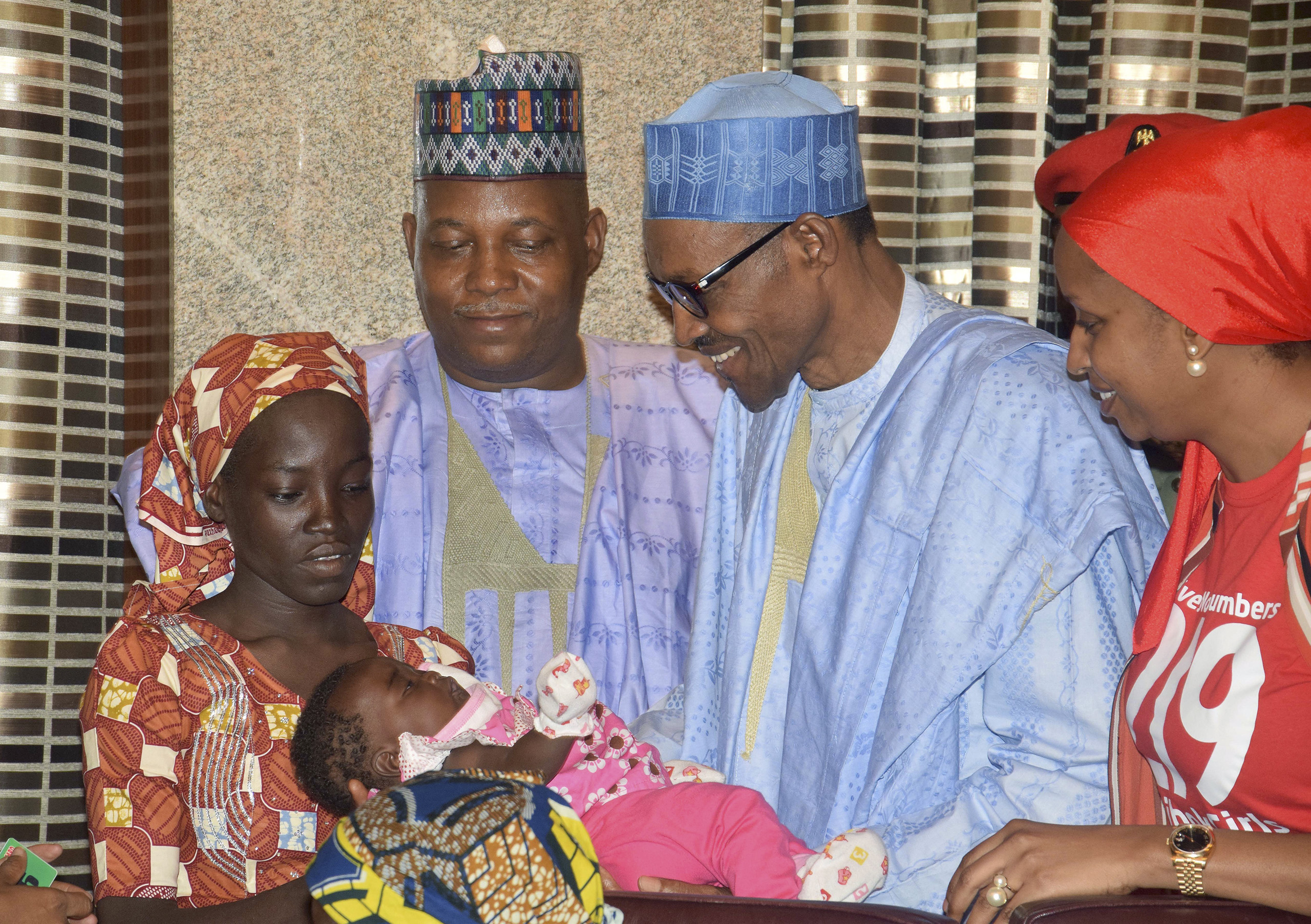 Nigerian President Muhammadu Buhari, second right, receives Amina Ali, the first rescued Chibok school girl, at the Presidential palace in Abuja, Nigeria, May. 19, 2016. (Azeez Akunleyan—AP)