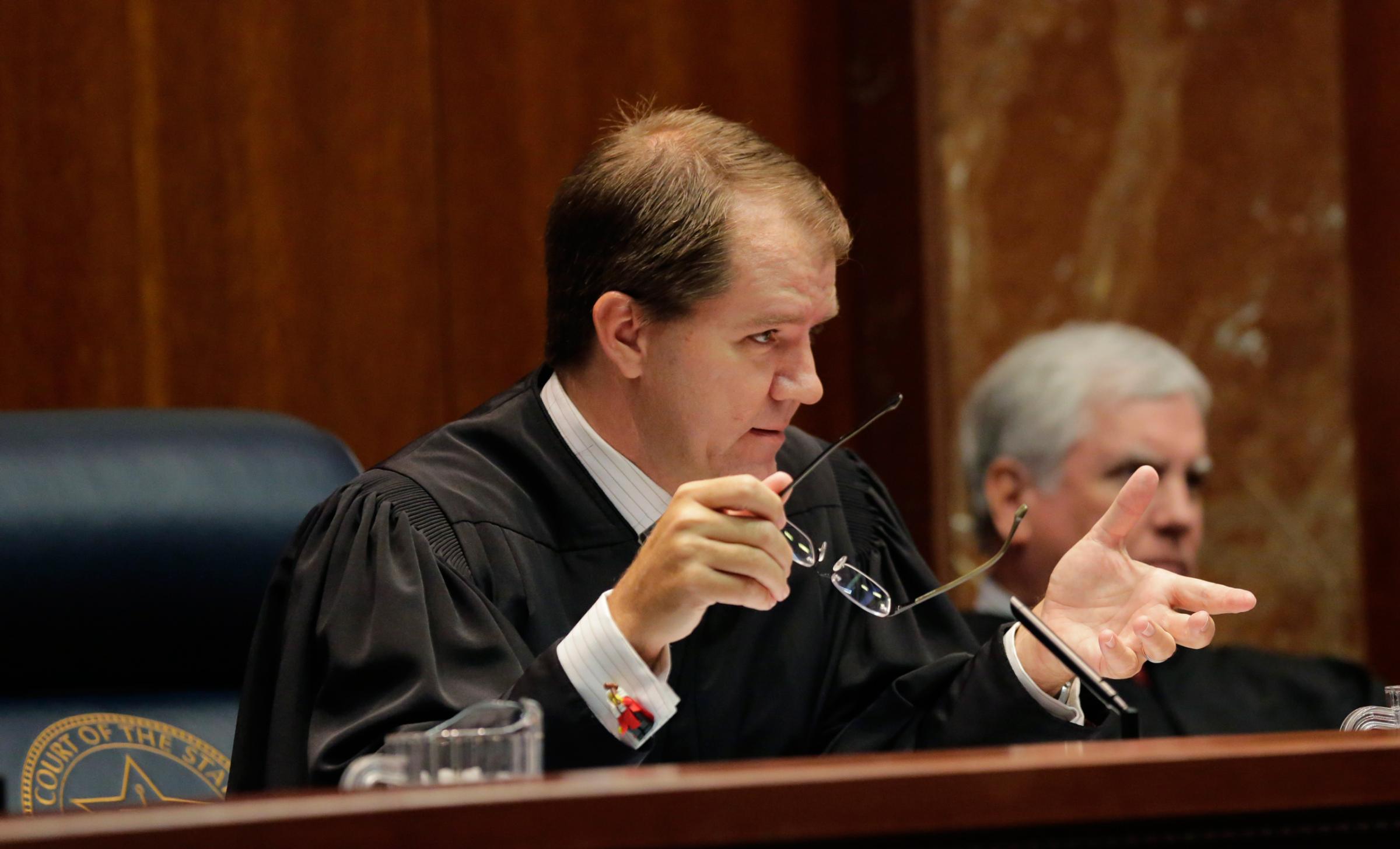Texas Supreme Court Justice Don Willett, left, asks a question during oral arguments in Texas' latest school finance case at the state Supreme Court, Tuesday, Sept. 1, 2015, in Austin, Texas. Attorneys for more than 600 school districts suing Texas argue that the funding is inadequate and unfairly distributed, making it hard for students and schools to meet stringent academic standards. Attorney General Ken Paxton's office counters that, while not perfect, public education money meets state constitutional requirements for an efficient system providing a "general diffusion of knowledge."(AP Photo/Eric Gay)