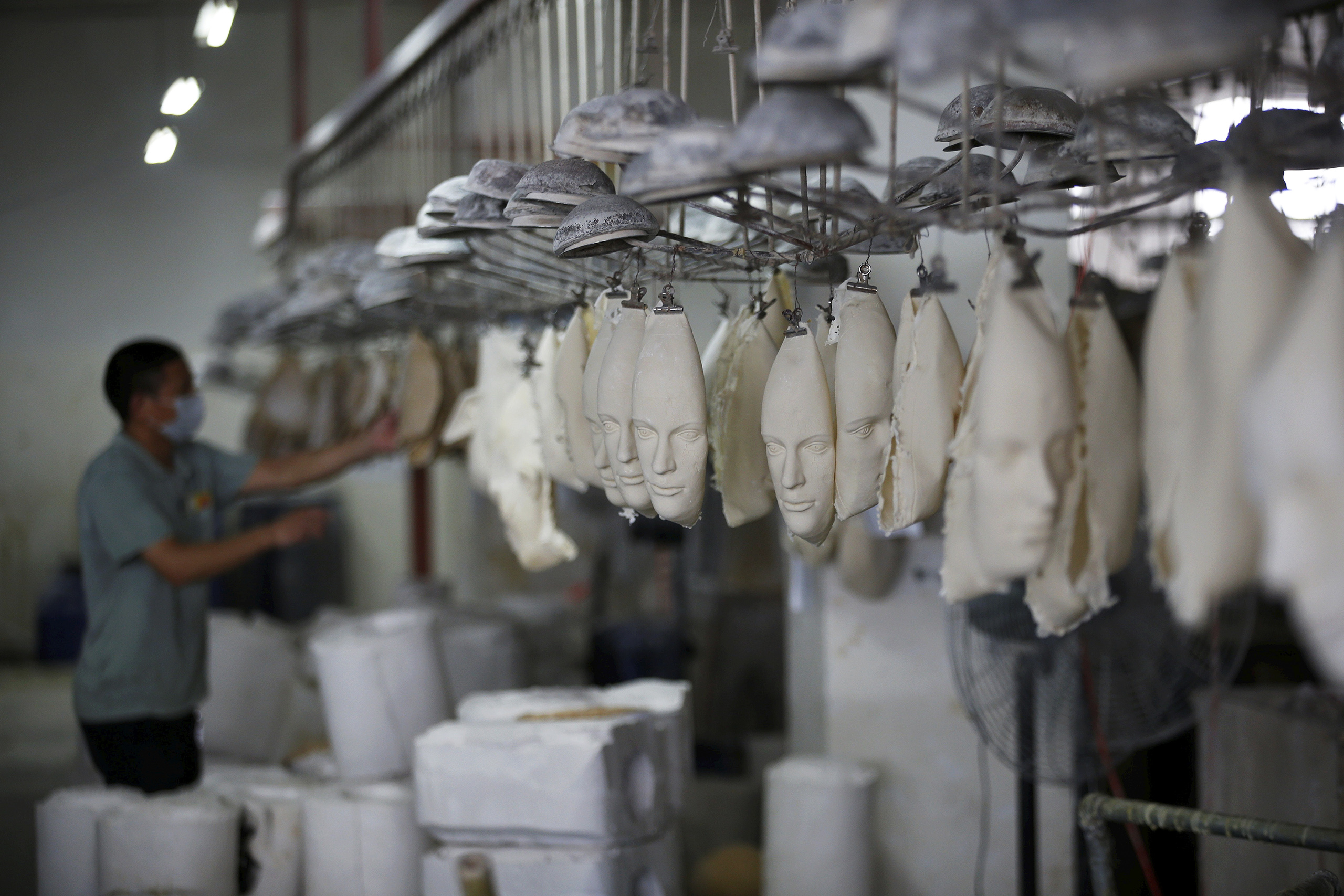 Masks hang during production at Jinhua Partytime Latex Art and Crafts Factory in Jinhua, Zhejiang Province, China, May 25, 2016.