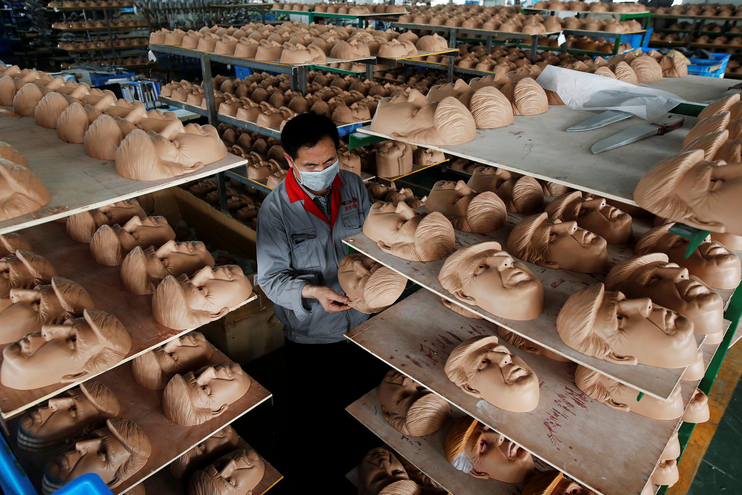 A worker checks a mask of Republican presidential candidate Donald Trump at Jinhua Partytime Latex Art and Crafts Factory in Jinhua, Zhejiang Province, China, May 25, 2016.