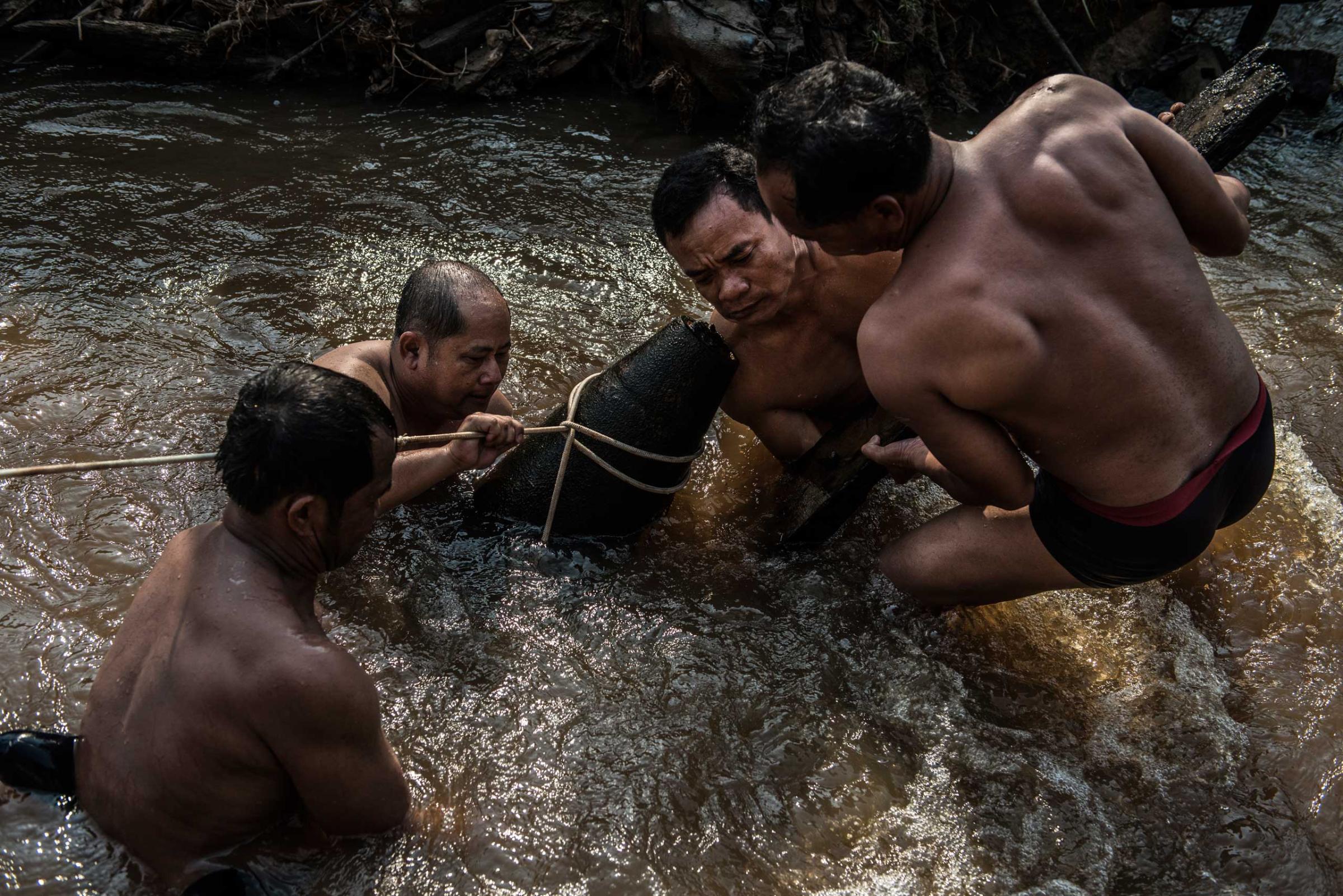 The UXO salvage dive team handles an unexploded 1000 pound bomb found in a river in Kratie Province, Cambodia in April 2015.