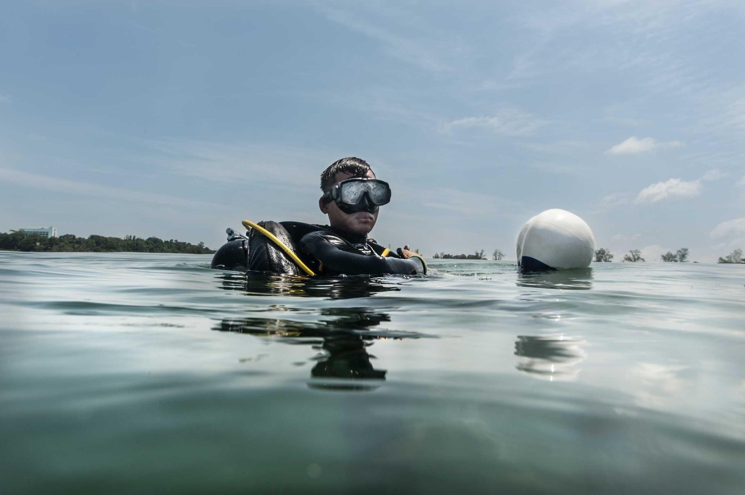UXO salvage diver Piseth Dara, 24, prepares to dive in July 2014. Dara is taking part in a training programme devised by the USA 7th Engineer Dive Detachment off the coast of Sihanoukville, Cambodia.
