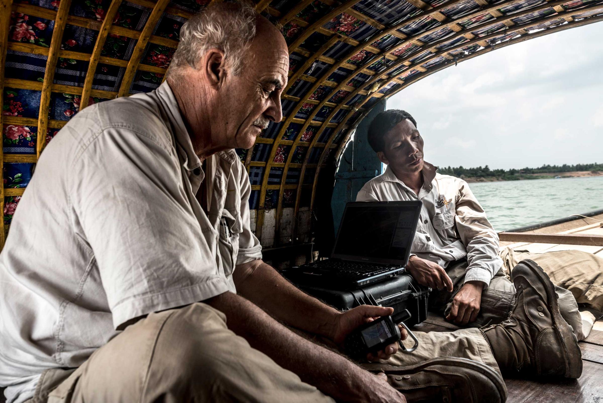 Marcel Durocher and Heang Sambo, employees of Golden West Humanitarian Organization, spend up to six hours a day on a boat when on a river survey. Using Sonar, Marcel and Sambo map the riverbed identifying sunken boats and potential UXO in April 2015. The Tonle Sap and Mekong rivers move vast amounts of sediment, making the process of scanning the river beds difficult, what is identified one year can be covered by sediment the next.