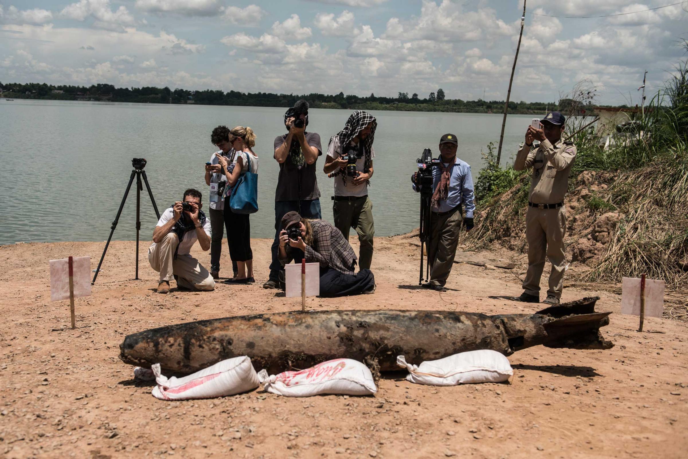 Journalists report on the MK82 Bomb which the diver team raised from the bottom of the Mekong River in March 2015.
