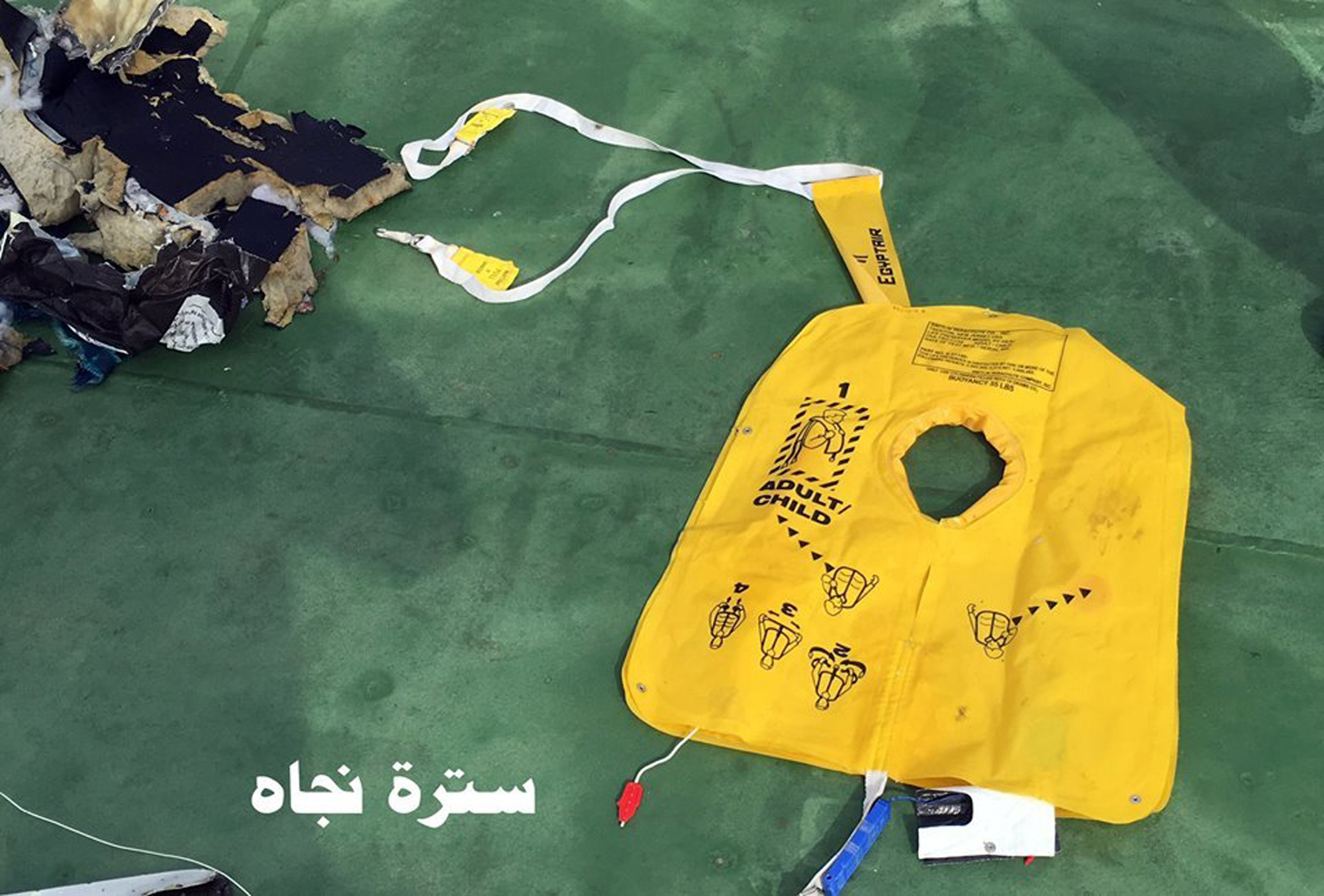 This picture posted Saturday, May 21, 2016, on the official Facebook page of the Egyptian Armed Forces spokesman shows a life vest from EgyptAir flight 804. Search crews found floating human remains, luggage and seats from the doomed EgyptAir jetliner Friday but face a potentially more complex task in locating bigger pieces of wreckage and the black boxes vital to determining why the plane plunged into the Mediterranean. Arabic reads: “ Life vest”. (Egyptian Armed Forces via AP)