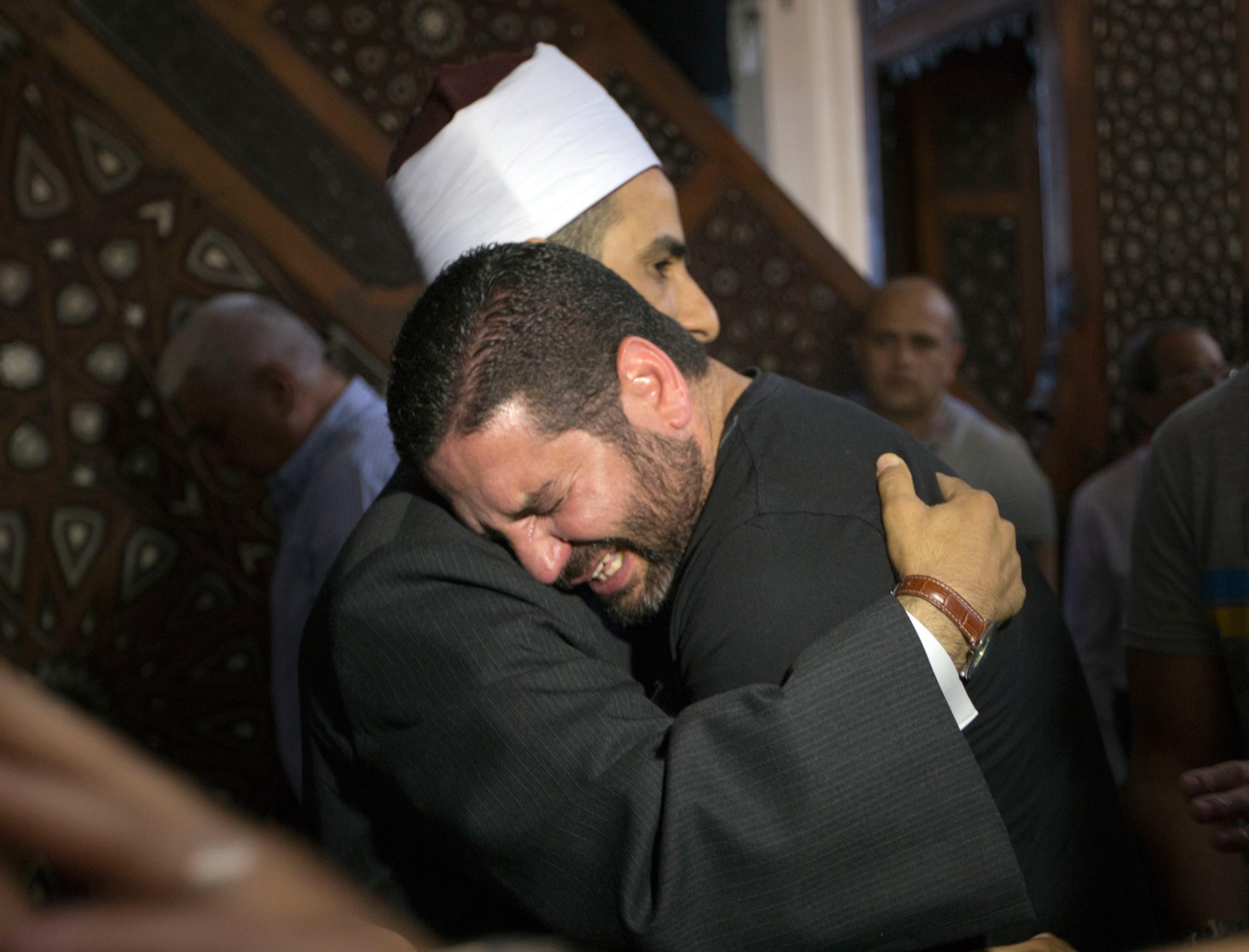 The Imam of al Thawrah Mosque, Samir Abdel Bary, gives condolences to film director Osman Abu Laban, center, who lost four relatives, all victims of Thursday's EgyptAir plane crash, following prayers for the dead, at al Thawrah Mosque, in Cairo, Egypt, Friday, May 20, 2016. The Airbus A320 plane was flying from Paris to Cairo when it disappeared early Thursday over the sea. (AP Photo/Amr Nabil)