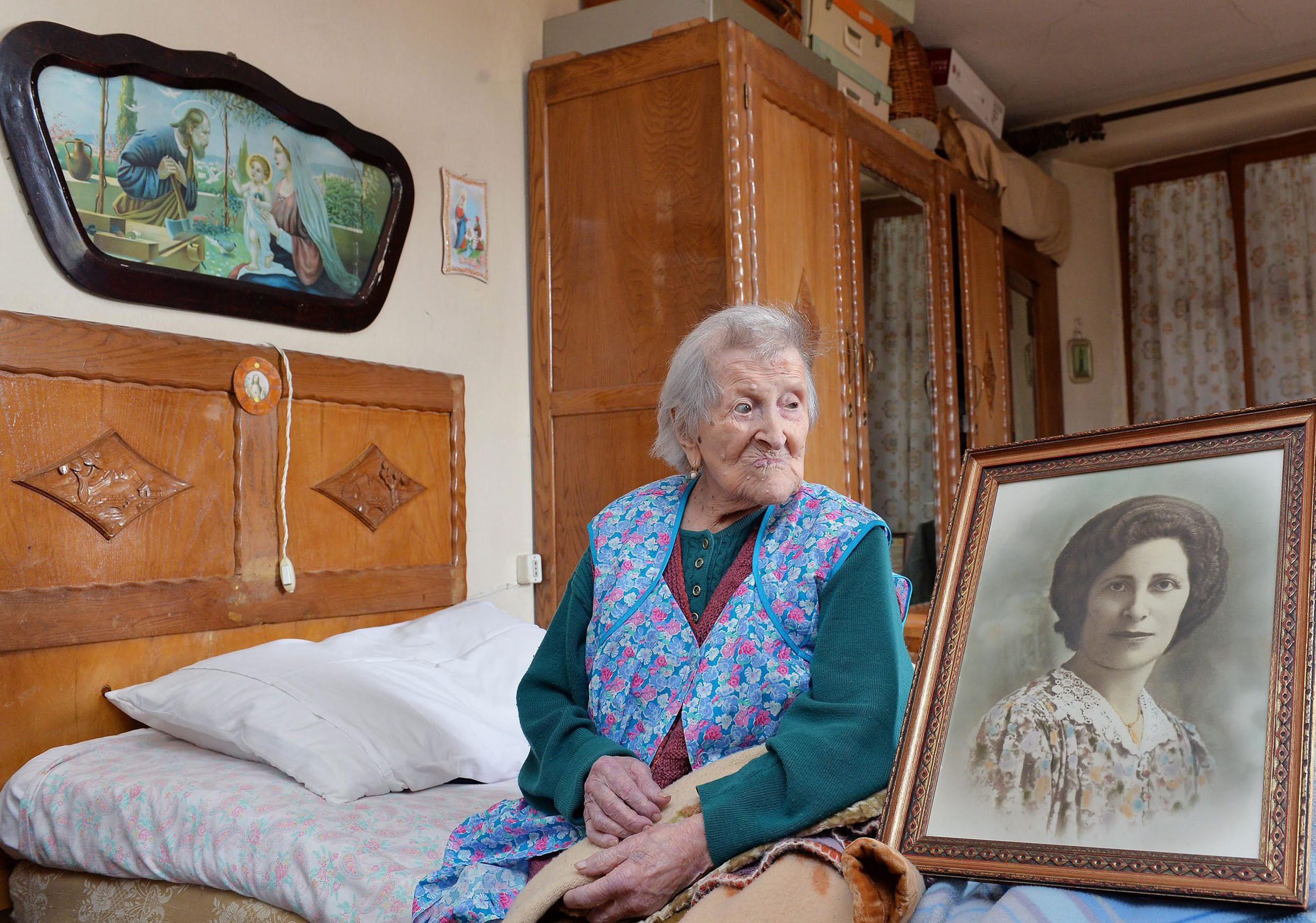 Emma Morano, 116, sits in her apartment nex to a picture depicting her where she was young in Verbania, northern Italy, May 13 2016. (Antonino di Marco—EPA)