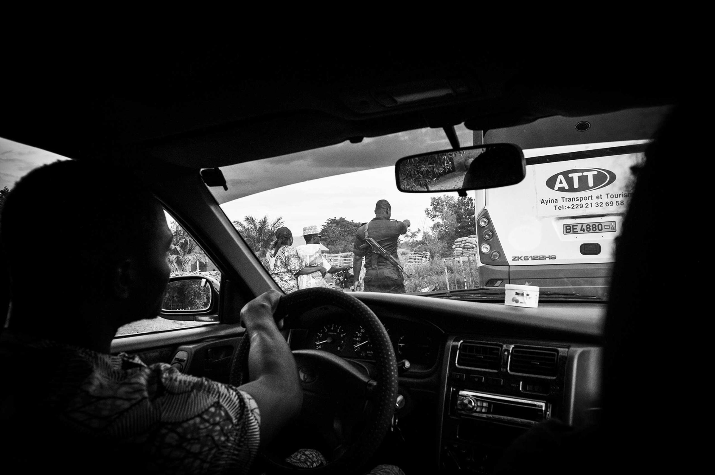 An agent of the gendarmerie in roadside check. The local authorities, both the Nigerian and the Beninese, profit from the illegal trafficking of petrol. The unregulated transportation of fuel is an illegal but frequent activity. The roadside checks of the gendarmerie and the army turn a blind eye or extort the drivers, who have no choice but to pay to ensure that the others don’t seize their goods.