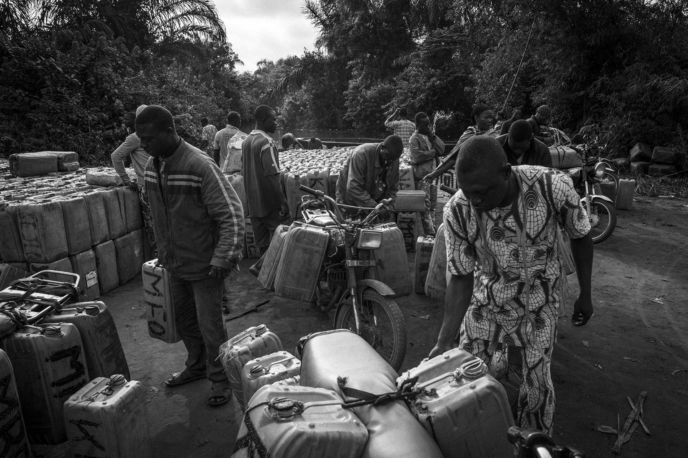 When the goods arrive on Beninese soil, hundreds of drivers wait on the seashore with their motorbikes for the arrival of the drums marked with the initials of their leaders. The first task of the motorcyclists is to identify the drums to load them up and assure properly on their motorbikes.