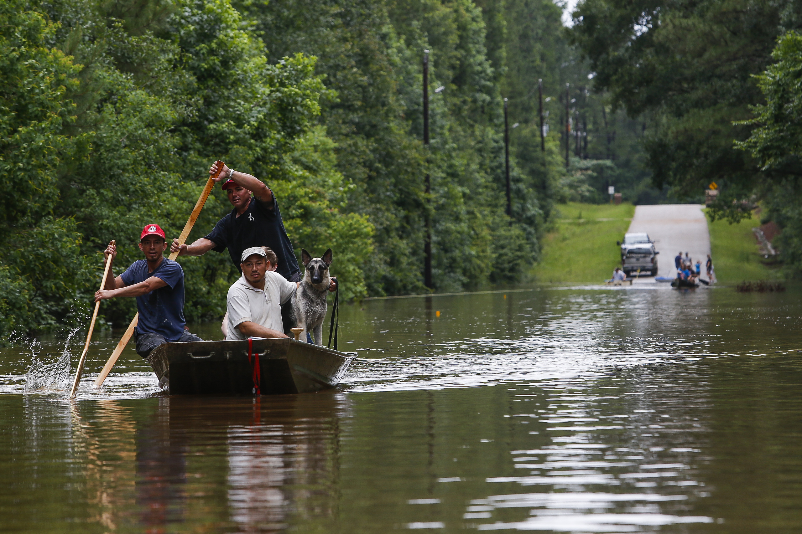 Roland Courville steers a boat across Mill Creek Road as he helps people escape from a neighborhood cut off by a flooded Spring Creek in Magnolia, Texas on May 27, 2016. (Michael Ciaglo—Houston Chronicle/AP)