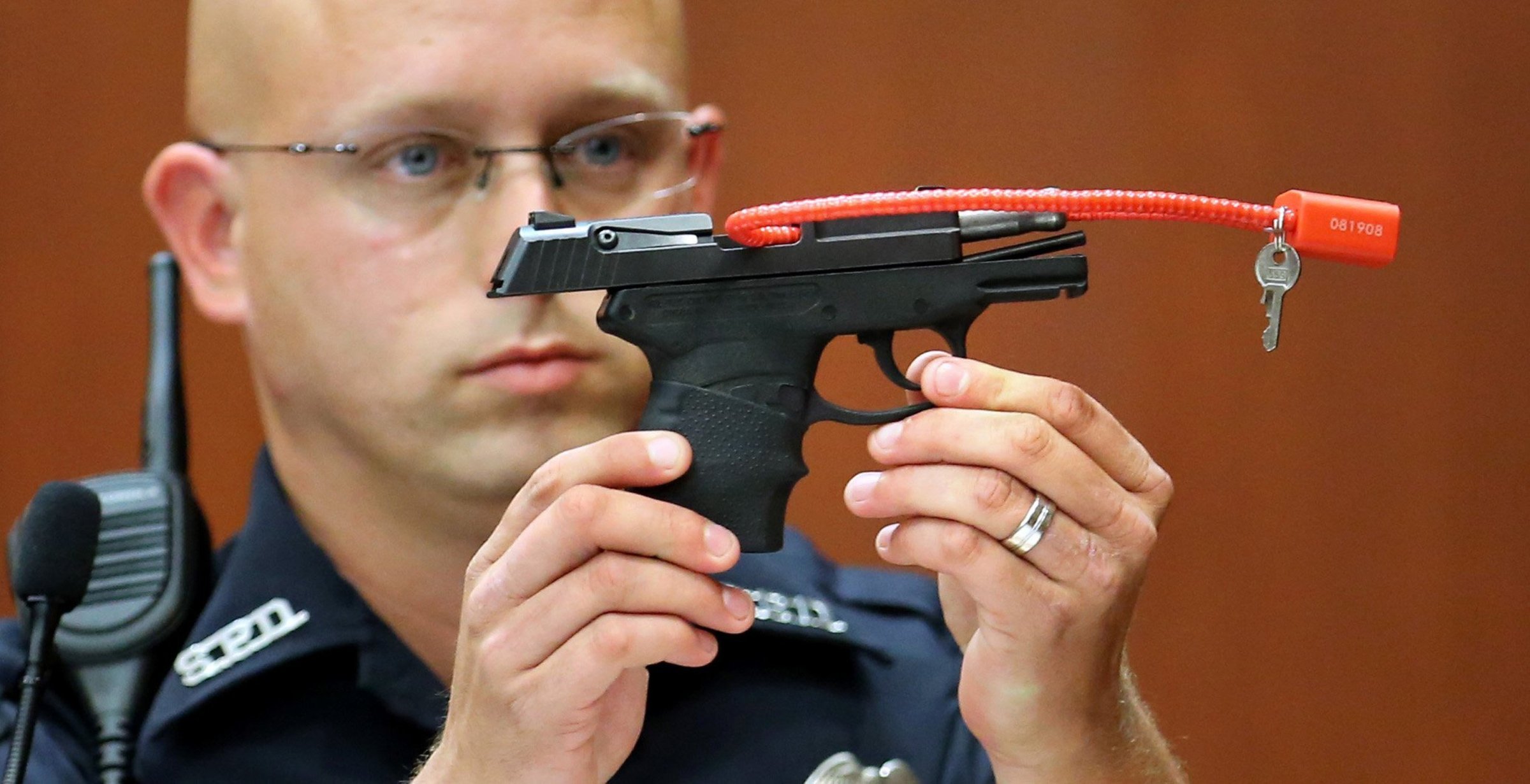 Sanford police officer Timothy Smith holds up the gun that was used to kill Trayvon Martin, while testifying in the 15th day of the George Zimmerman trial, in Seminole circuit court in Sanford, Florida, Friday, June 28, 2013.