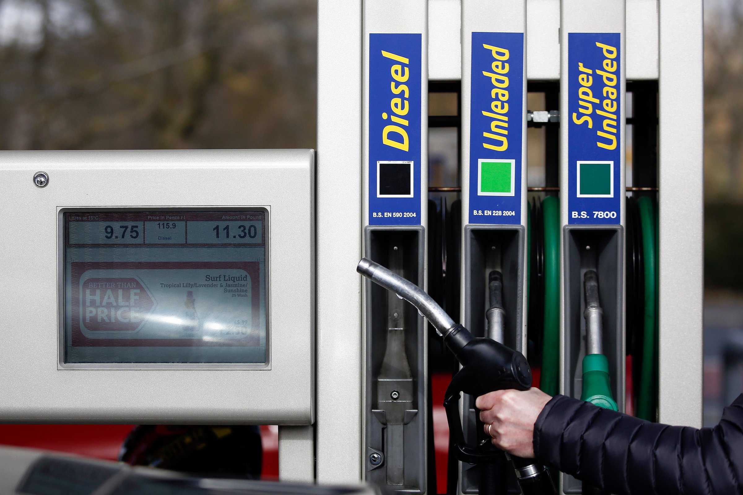 An employee holds a fuel nozzle as he prepares to refuel a diesel automobile on the forecourt of a JET petrol station, operated by Phillips 66, in Portsmouth, U.K., on March 6, 2015.