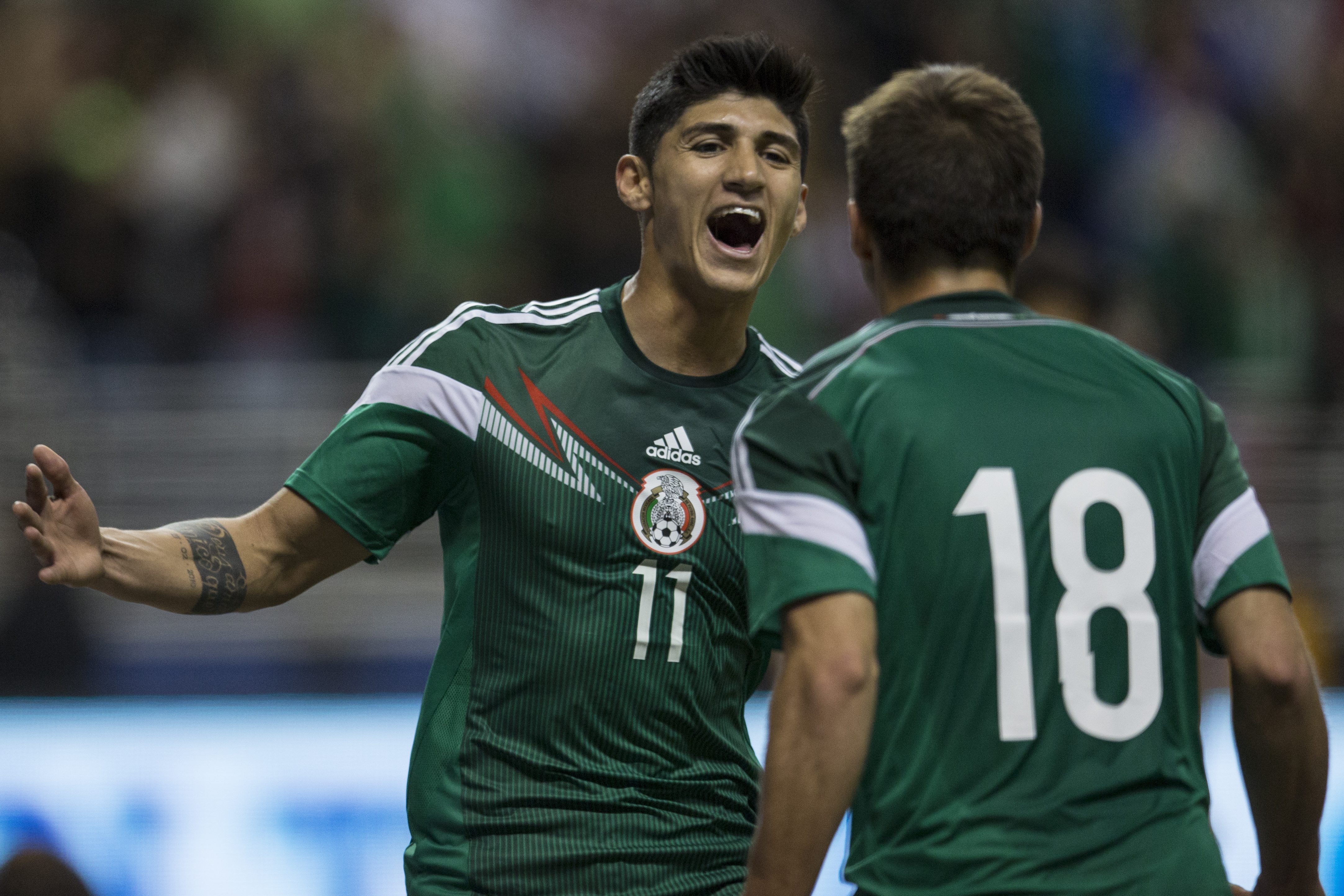 Alan Pulido (L) of Mexico celebrates his second goal with Isaac Brizuela during a FIFA friendly match between Mexico and South Korea at Alamodome Stadium on January 29, 2014 in San Antonio, United States. (Miguel Tovar—STF/LatinContent/Getty Images)