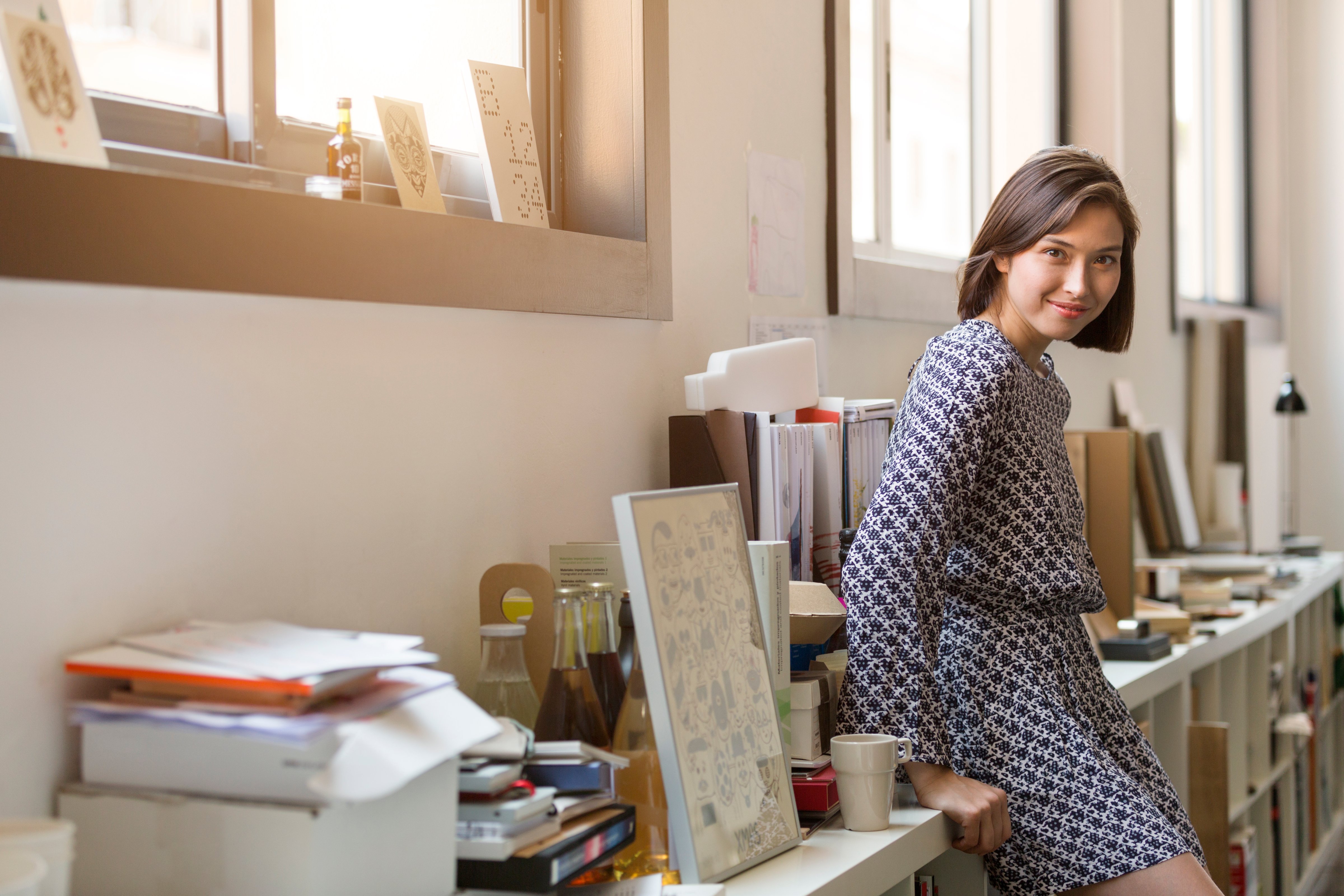 Side view portrait of smiling businesswoman leaning on shelf in office (Morsa Images&mdash;Getty Images)