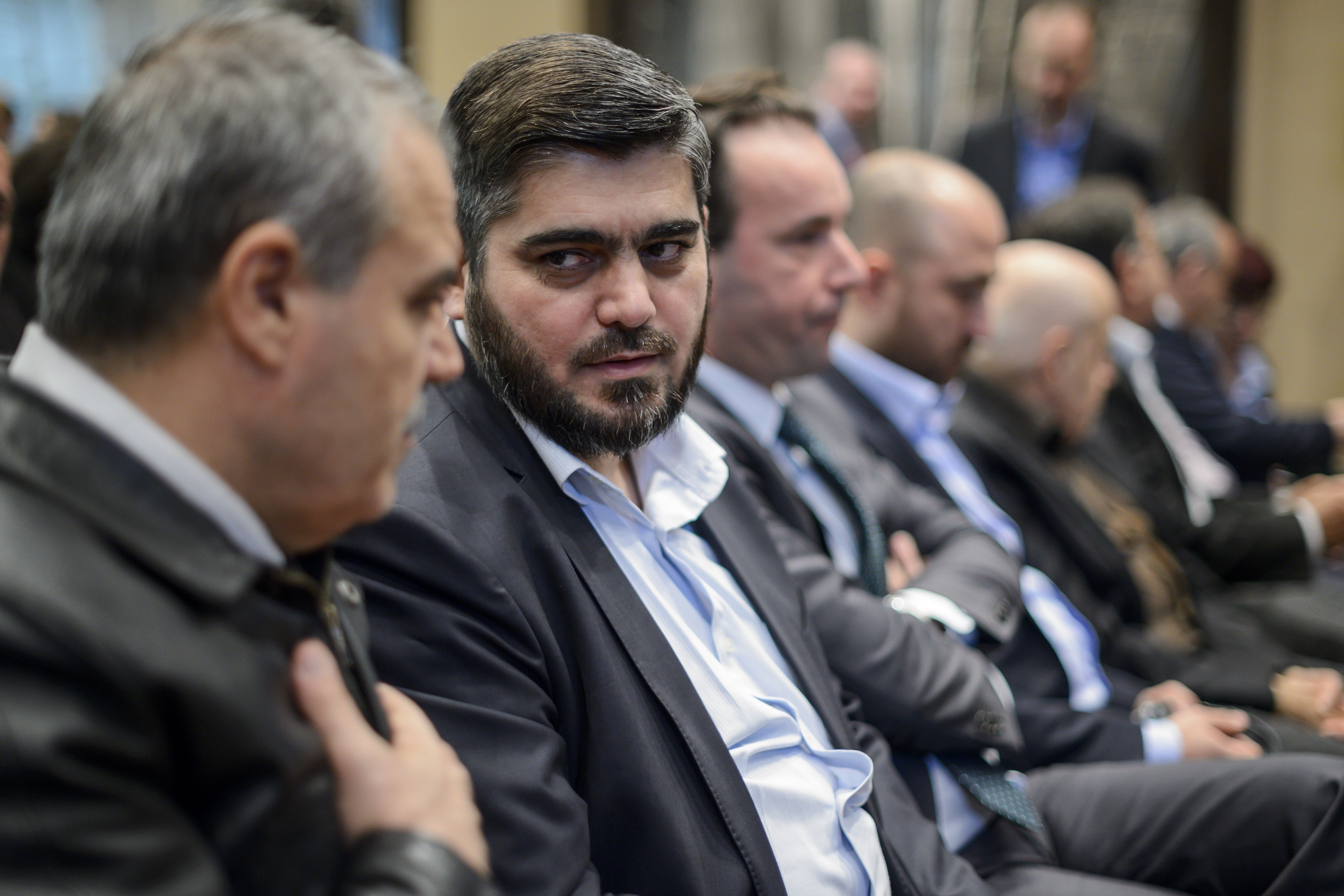 Chief negotiator for the main Syrian opposition body, Mohammed Alloush (2nd L) speaks with delegation head Asaad al-Zoabi in Geneva on April 19, 2016 (Fabrice Coffrini—AFP/Getty Images)