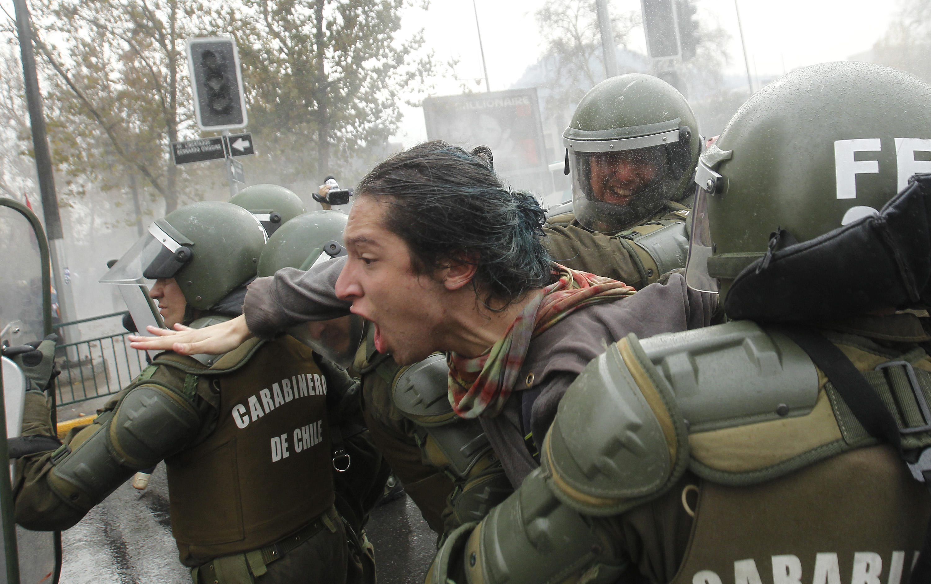 Riot police arrest a student during a march held to protest the slow pace of educational reform, in Santiago, on May 26, 2016 (Claudio Reyes—AFP)