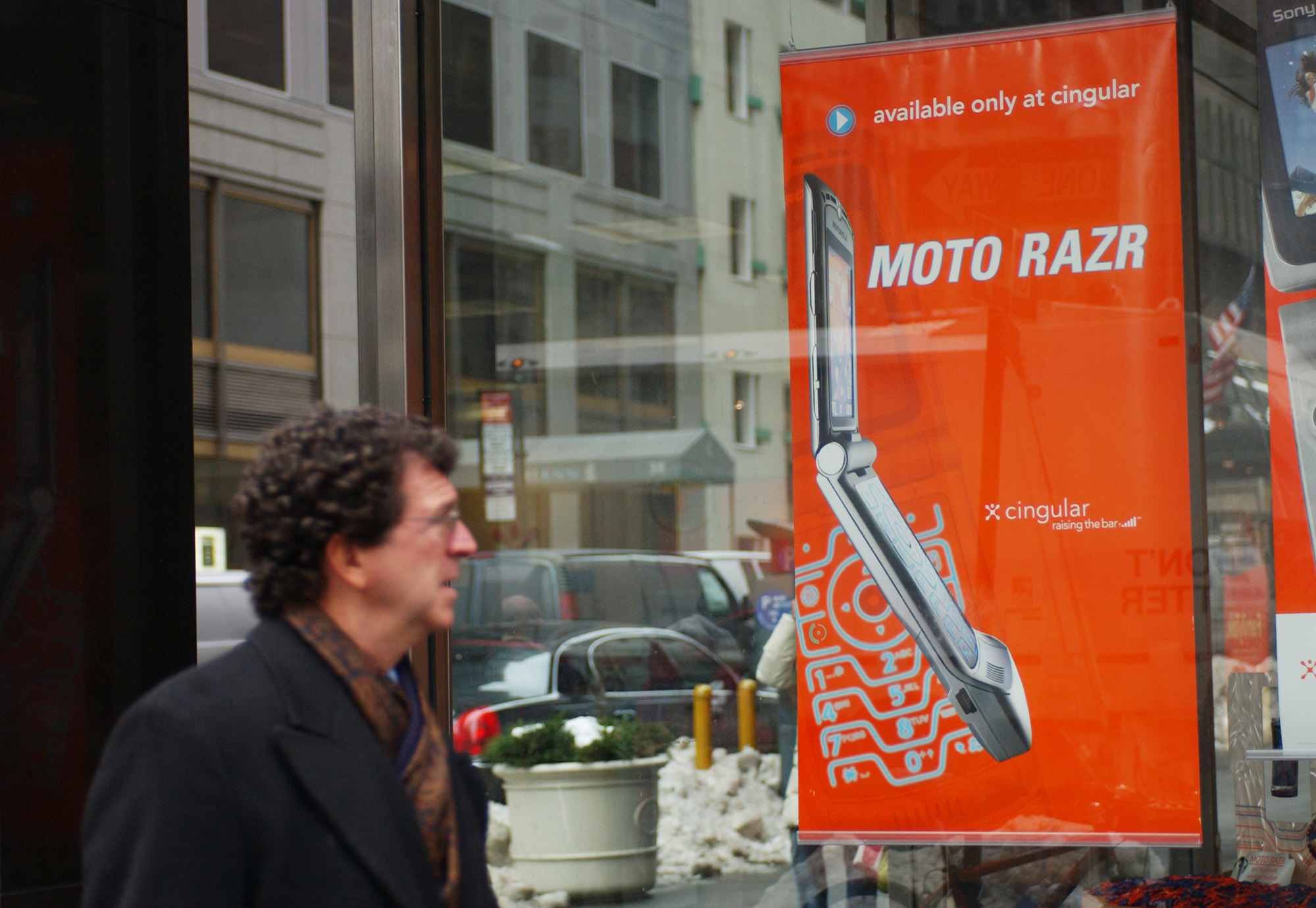 A pedestrian looks at an advertisement for Motorola's new Razr phone the window of a Cingular Wireless store in New York, Wednesday, January 26, 2005. (Bloomberg&mdash;Bloomberg via Getty Images)