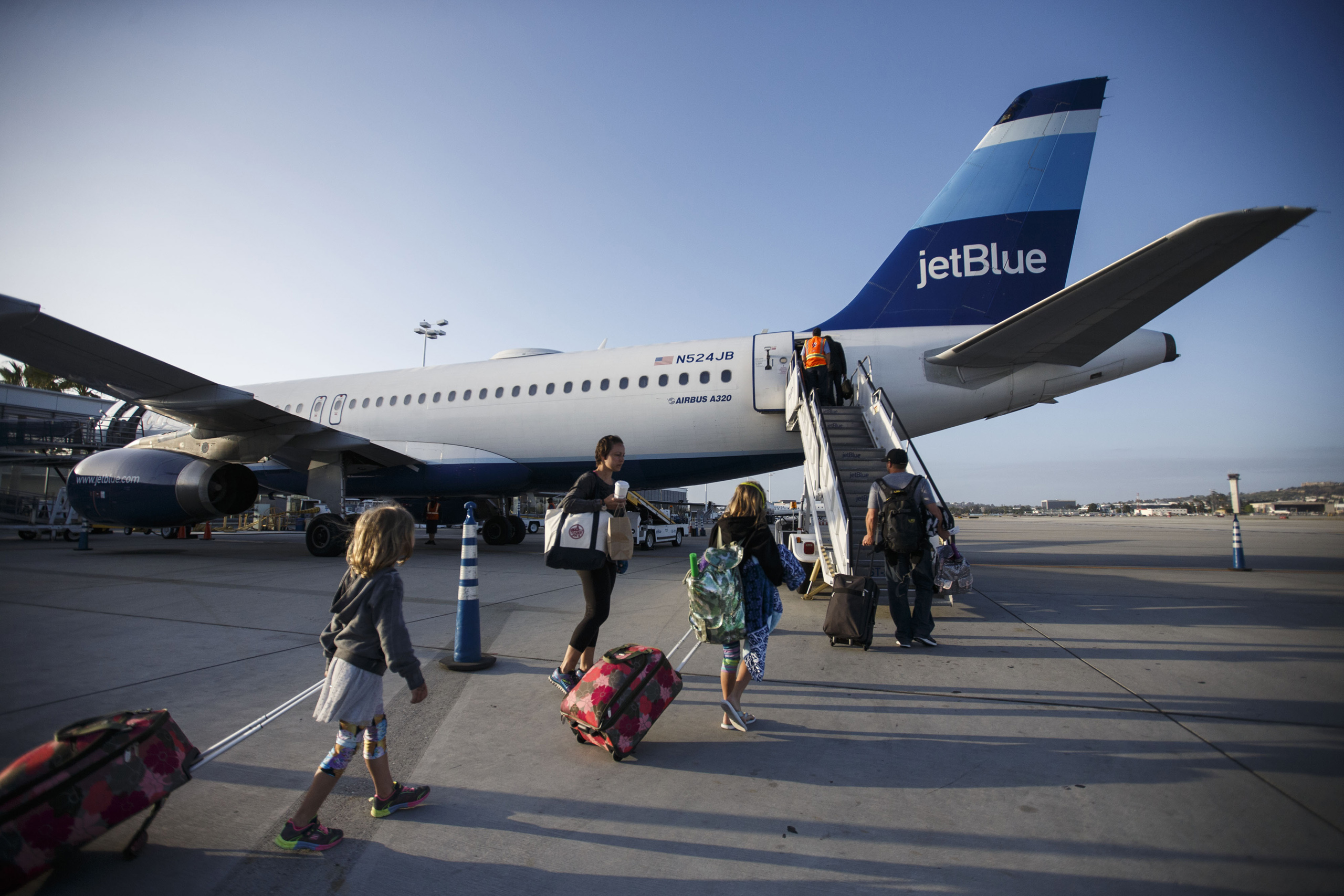 Travelers board a JetBlue Airways Corp. Airbus Group SE A320 aircraft on the tarmac at Long Beach Airport (LGB) in Long Beach, Calif. on April 25, 2016. (Patrick T. Fallon—Bloomberg/Getty Images)