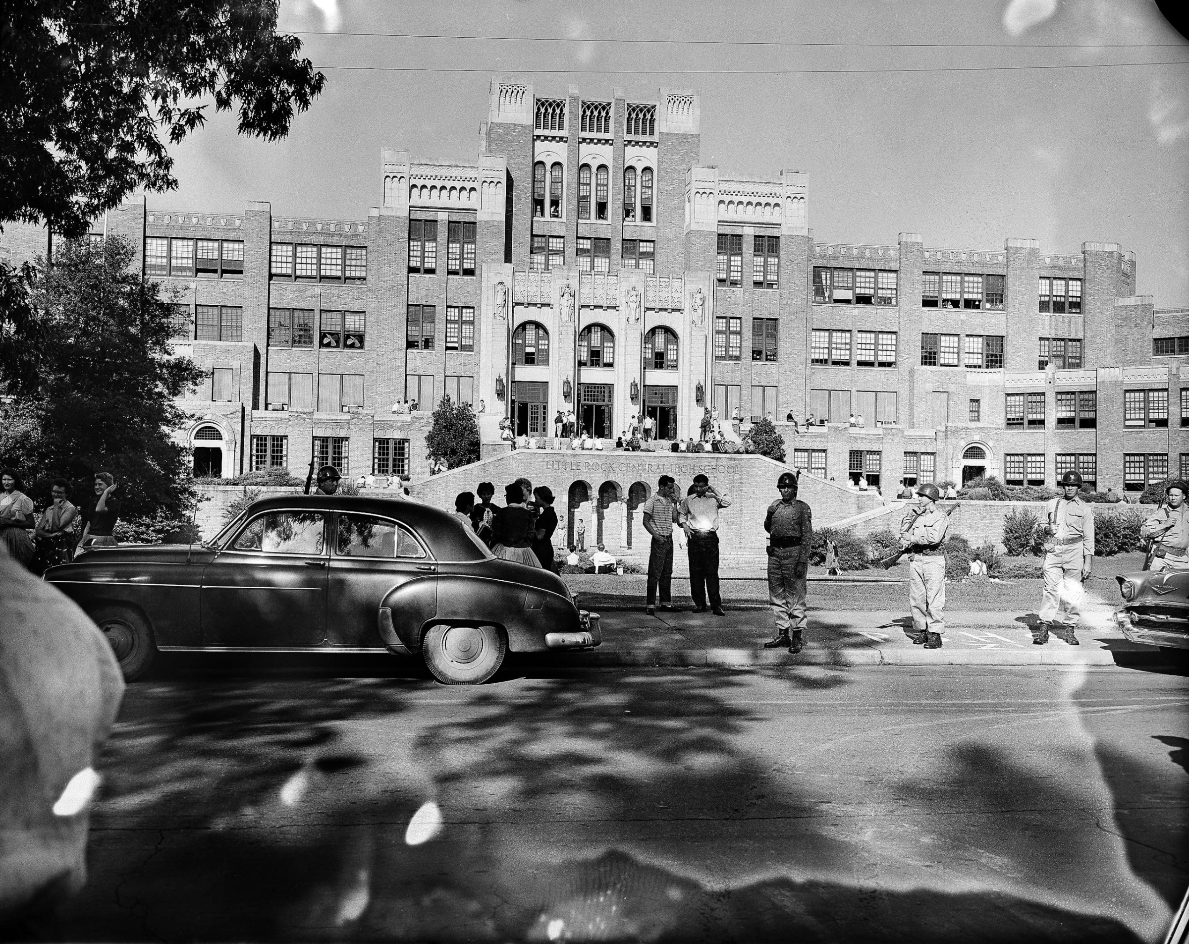 Only a small crowd of people gather in front of Little Rock Central High School the morning of Sept. 16, 1957. There were no incidents, with no black students trying to enter the school. Gov. Orval Faubus has kept guardsmen around the building for more than two weeks - ever since the day before school opened. He has not definitely indicated if and when the troops will be withdrawn. (AP Photo/Henry Griffin)