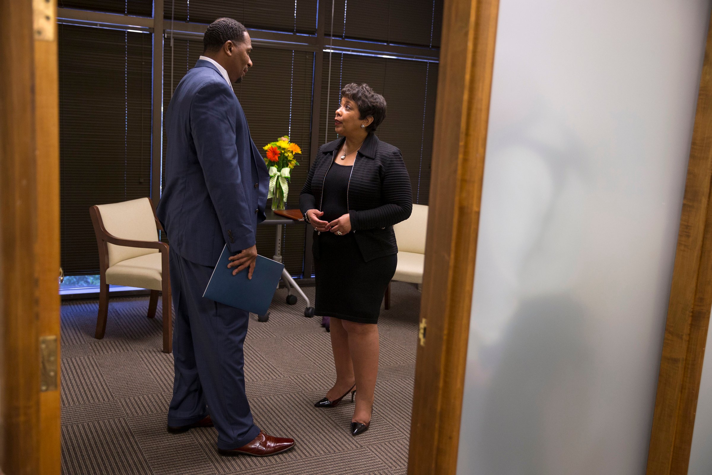 Attorney General Loretta Lynch, right, speaks with Clarence Aaron about his experiences after his release from federal prison during an event to highlight policies that aim to reduce barriers for formerly incarcerated individuals in Mobile, Ala., April 29, 2016.