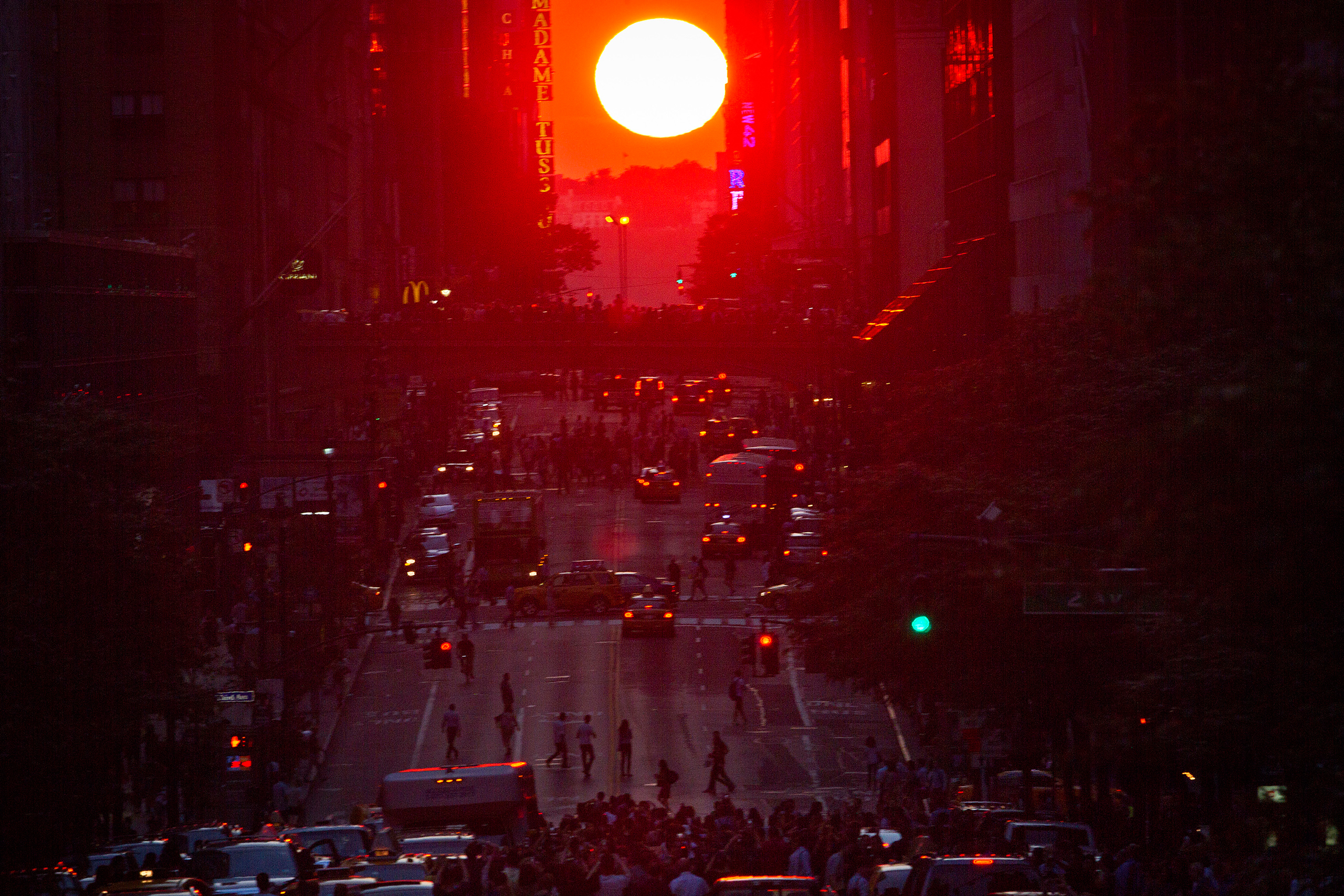 People crowd onto 42nd Street as they take photos of the "Manhattanhenge" phenomenon in New York City on July 11, 2014. (Carlo Allegri—Reuters)