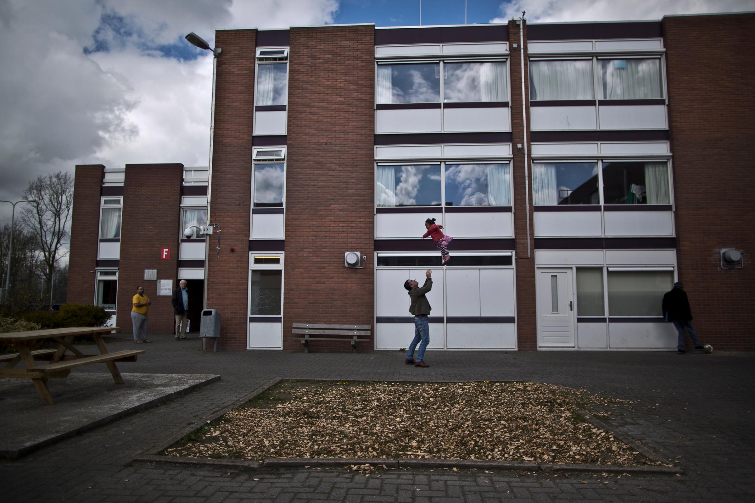 A migrant plays with a girl at the former prison of Westlingen in Heerhugowaard, northwestern Netherlands, April 8, 2016.
