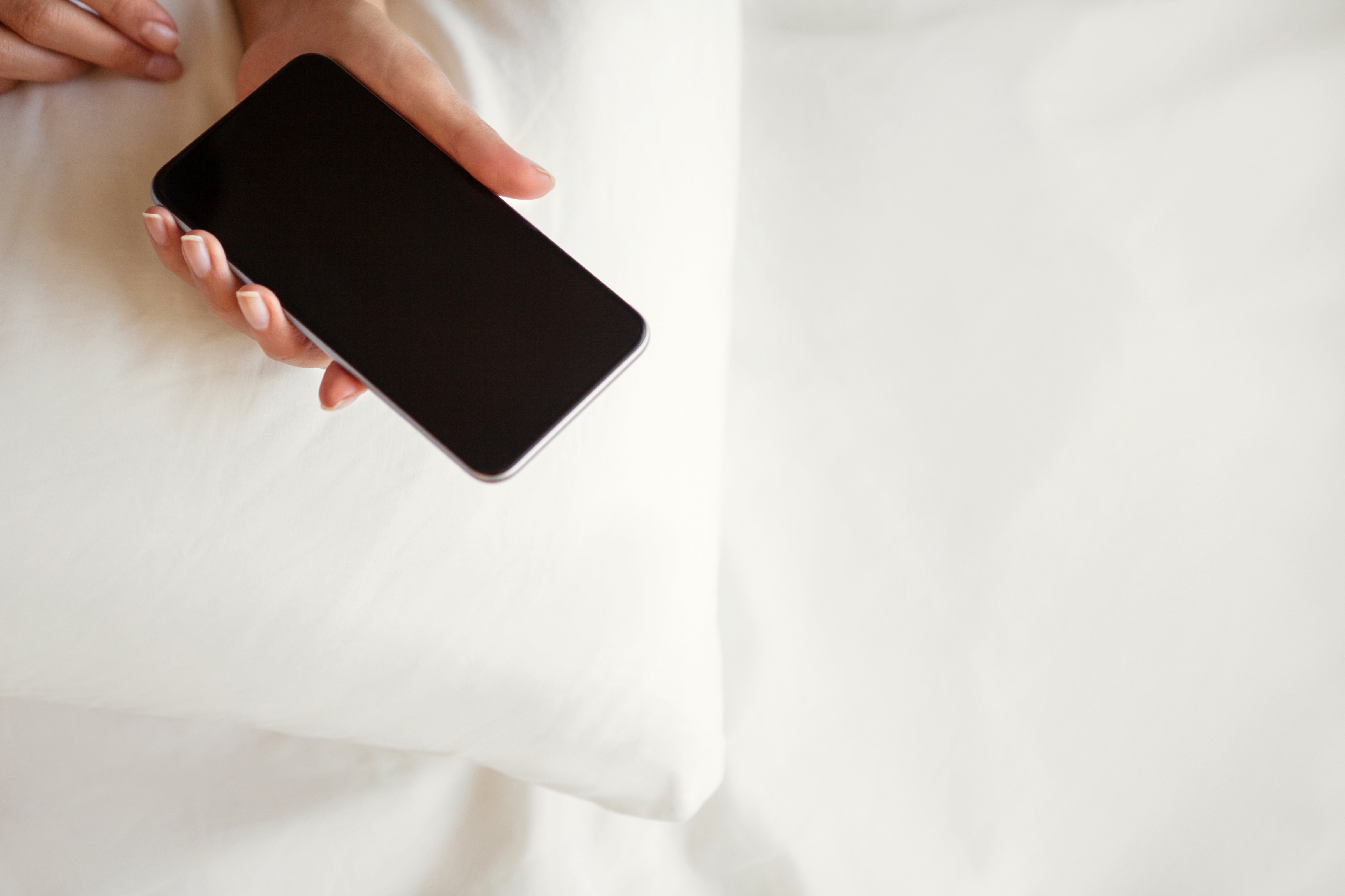 Woman using smartphone in bed (Erik Khalitov—Getty Images/iStockphoto)