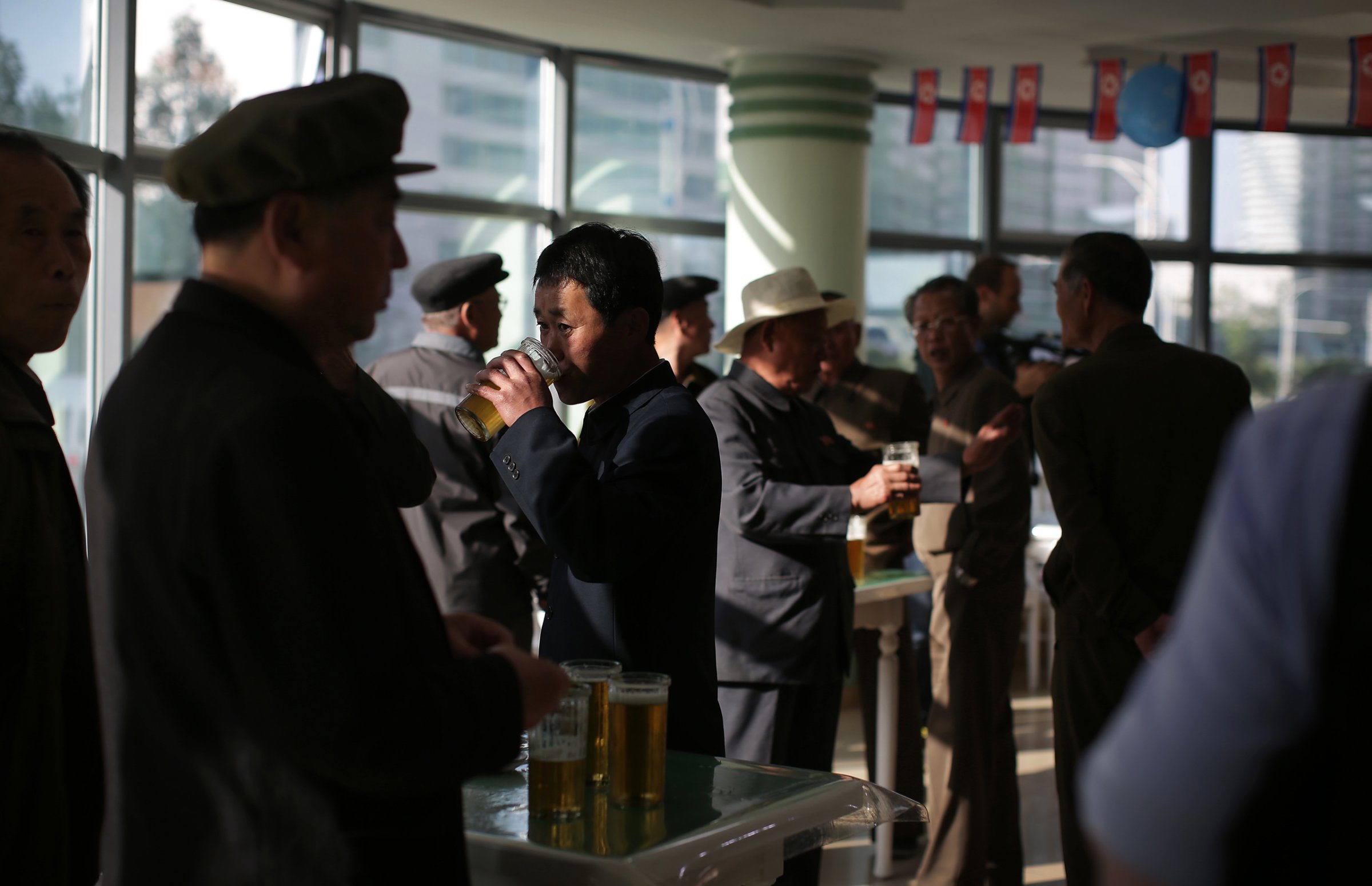 In this Saturday, May 7, 2016, photo, North Korean men drink beer at the Taedonggang Beer shop in Pyongyang, North Korea. Ahead of the ongoing congress of North Korea's ruling Workers' Party, the nation was called upon to do massive overtime to boost production and show their devotion to leader Kim Jong Un in a 70-day "loyalty campaign." And that's in addition to the hour after hour of rehearsals for huge rallies when their ruling party wraps up its first congress in decades. So how does a tired North Korean unwind? Beer. Beer. And more beer. (AP Photo/Wong Maye-E)