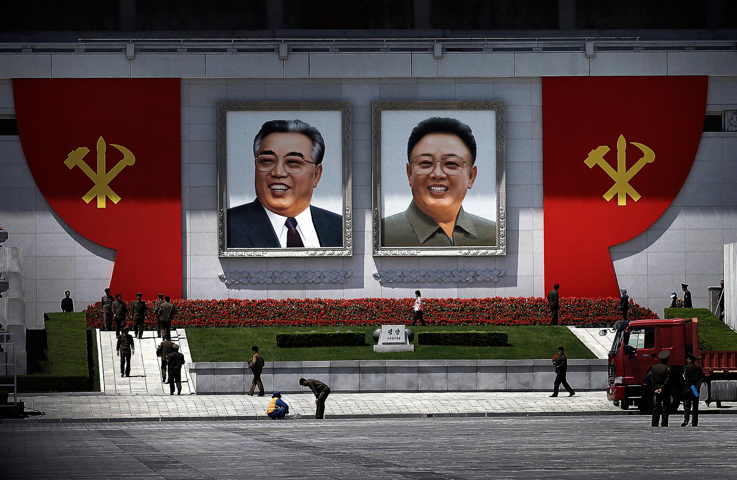 The ruling Workers' Party symbols are erected by the portraits of the late North Korean leaders Kim Il Sung, left, and Kim Jong Il while workers decorate the vicinity with flowers at the Kim Il Sung Square Saturday, May 7, 2016 in Pyongyang, North Korea. North Korean leader Kim Jong Un hailed his country's recent nuclear test to uproarious applause as he convened the first full congress of its ruling party since 1980, an event intended to showcase the North's stability and unity in the face of tough international sanctions and deepening isolation. (AP Photo/Wong Maye-E)