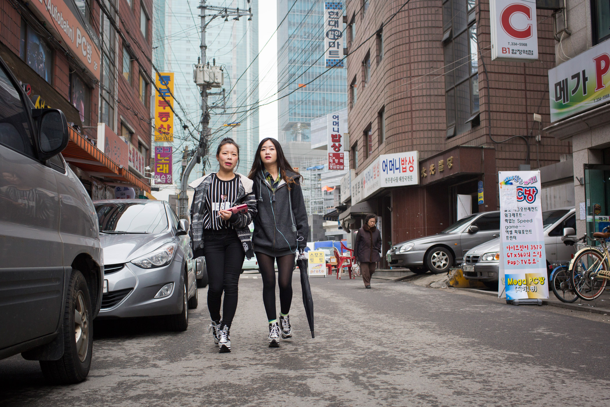 Donning matching shoes, North Korean refugees Kim Kyong-ok, 19 (Lunar age), and Sarah (English name used in order to protect source), 22, walk arm-in-arm on their way to a Christian church service on Feb. 21, 2015 near Hapjeong, Seoul, South Korea. The women met shortly after they each arrived separately in South Korea at a resettlement camp for refugees. While adjusting to life after North Korea has been challenging, their friendship is a source of strength and solidarity. Caitlin O'Hara