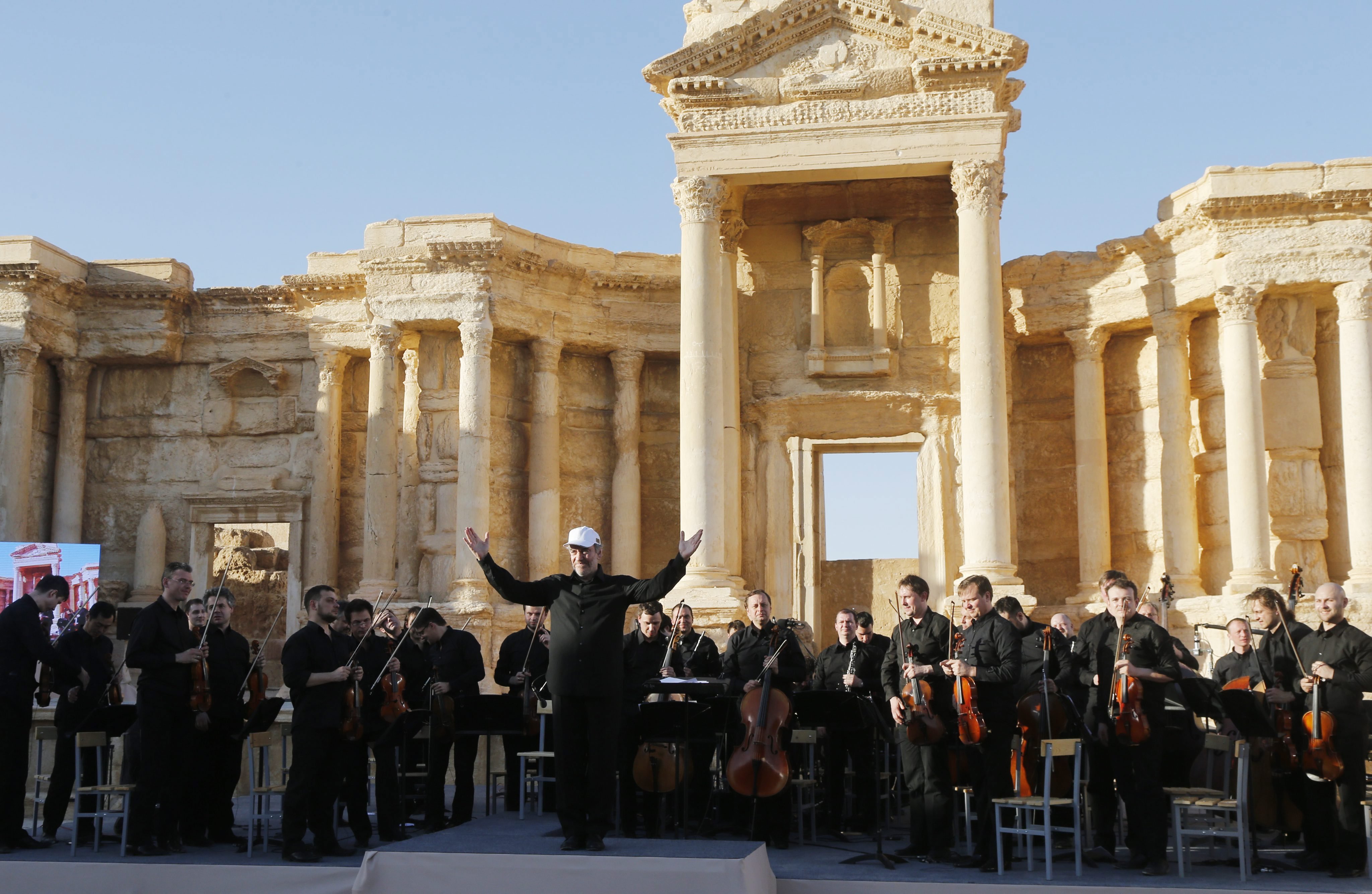 Chief conductor of the Mariinsky Theater Orchestra Valery Gergiev greets the public after a concert in in the Palmyra amphitheater in Syria, on May 5, 2016. (Sergei Chirikov—EPA)
