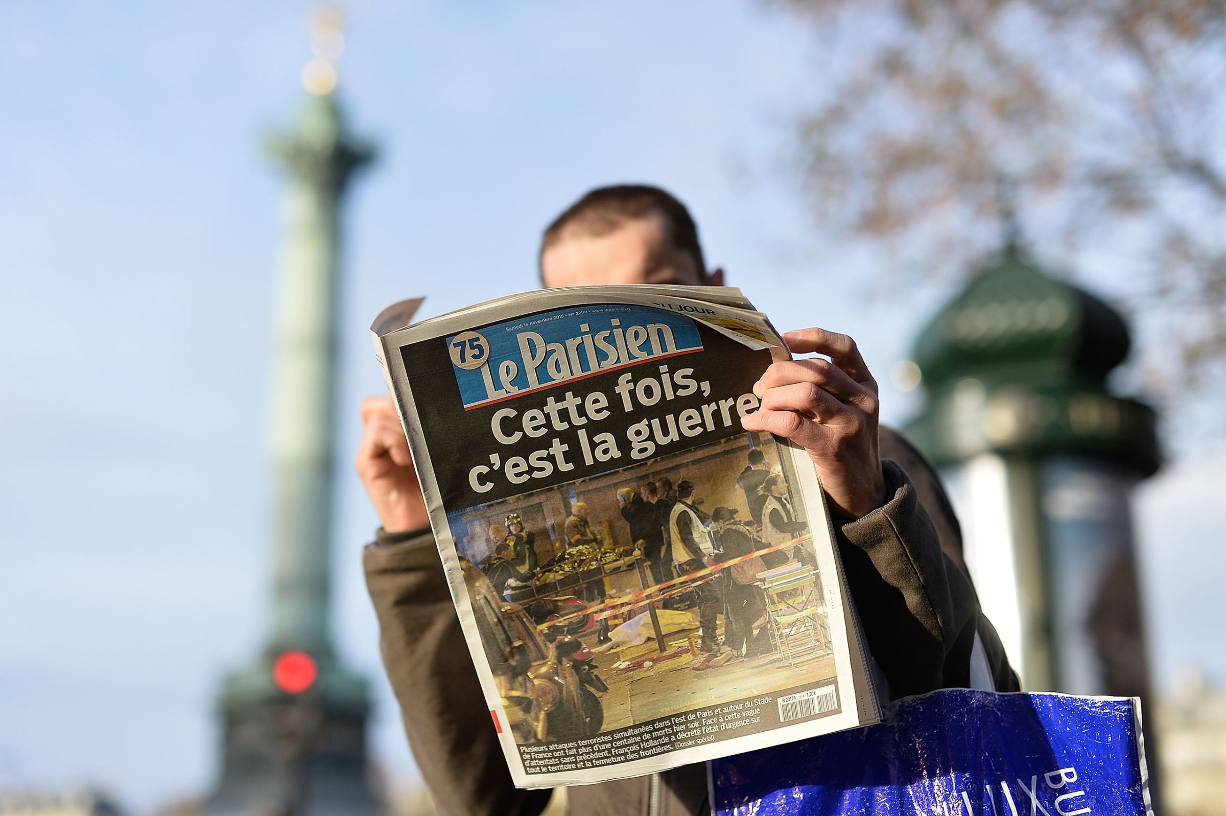 A man reads a French newspaper after a terrorist attack in Paris on Nov. 14, 2015.