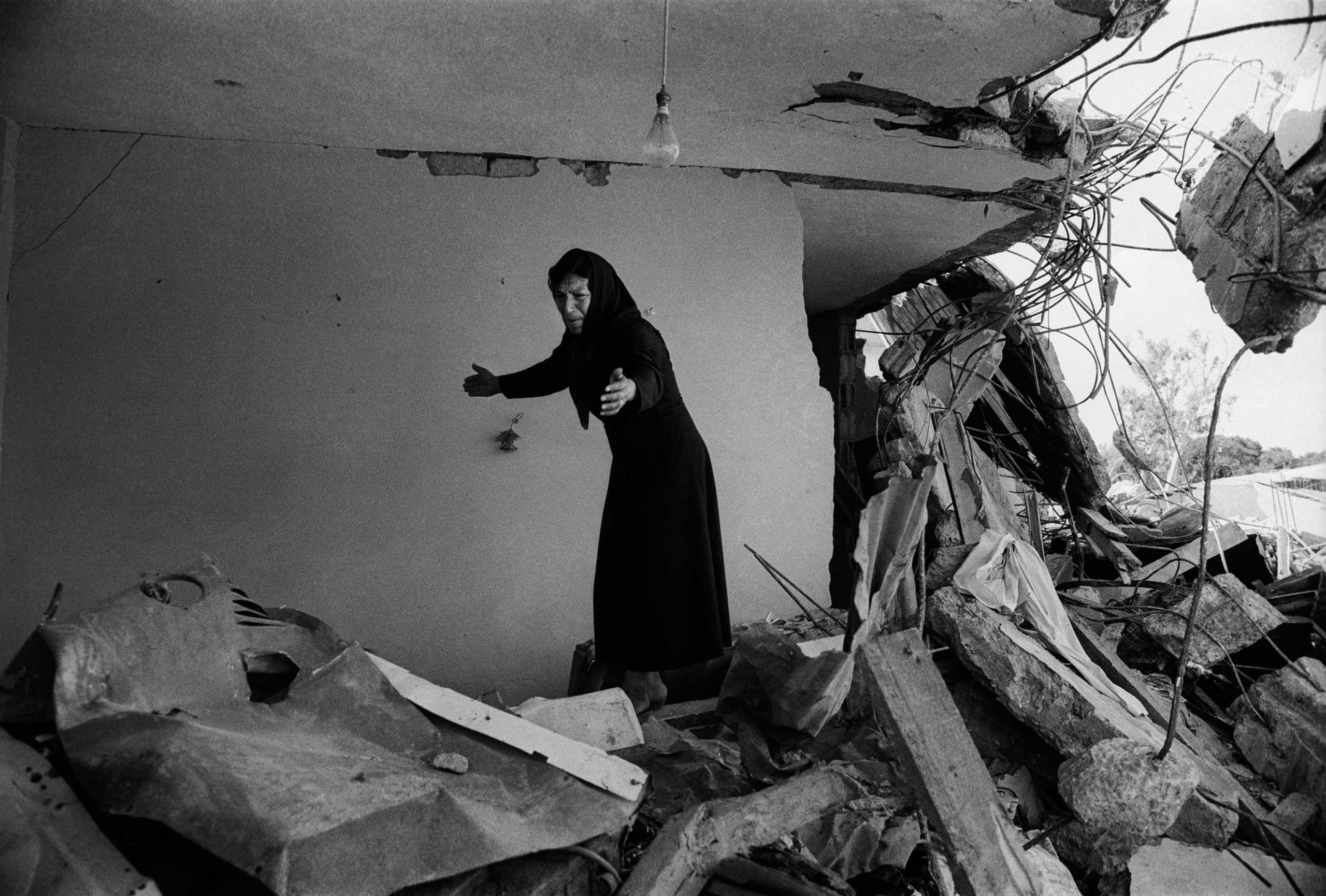 A Palestinian Woman returning to the ruins of her house in Sabra, Beirut, 1982.