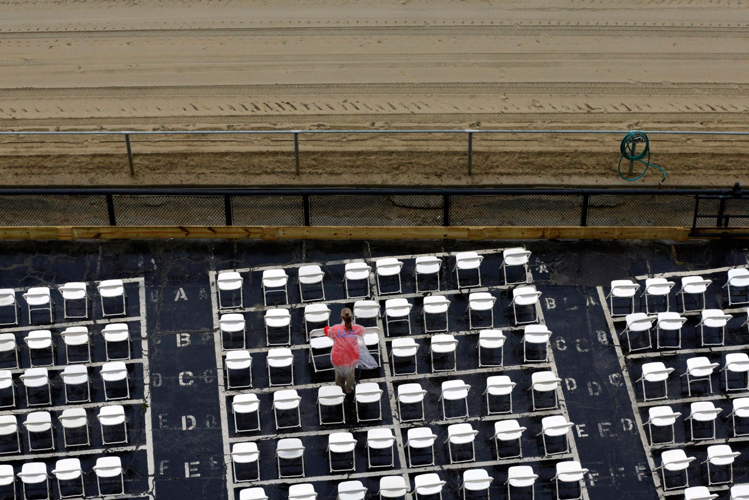 An usher clears water off of trackside seats as rain falls before the 141st running of the Preakness Stakes horse race at Pimlico Race Course in Baltimore, Saturday, May 21, 2016. (AP Photo/Patrick Semansky)