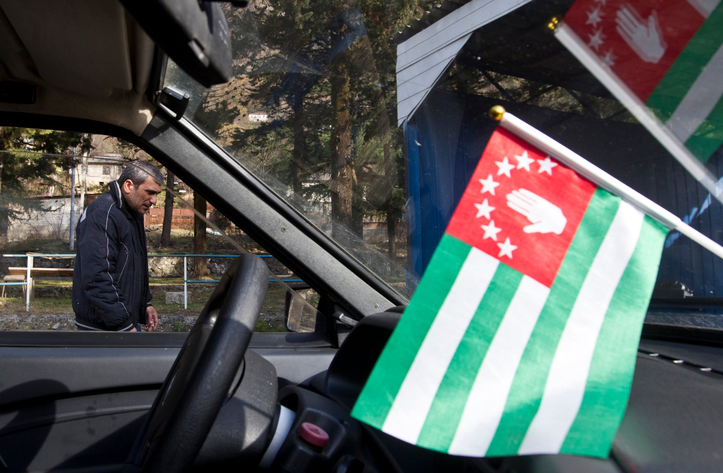 A flag of Abkhazia is on display inside a car in the town of Tkvarcheli