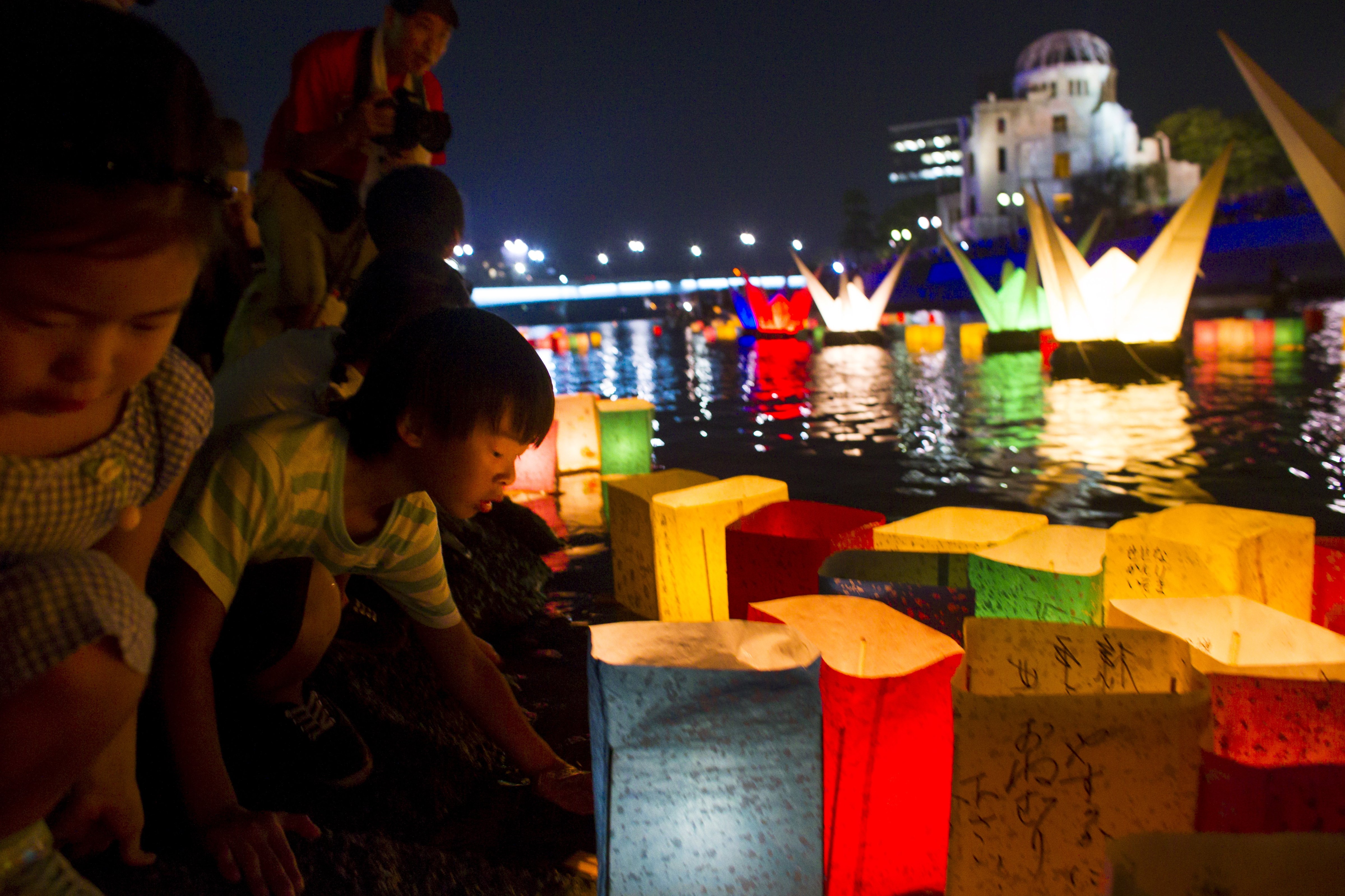 Children release lanterns into the Motoyasu river in front of the Atomic Bomb Dome to remember the atomic bomb victims in Hiroshima