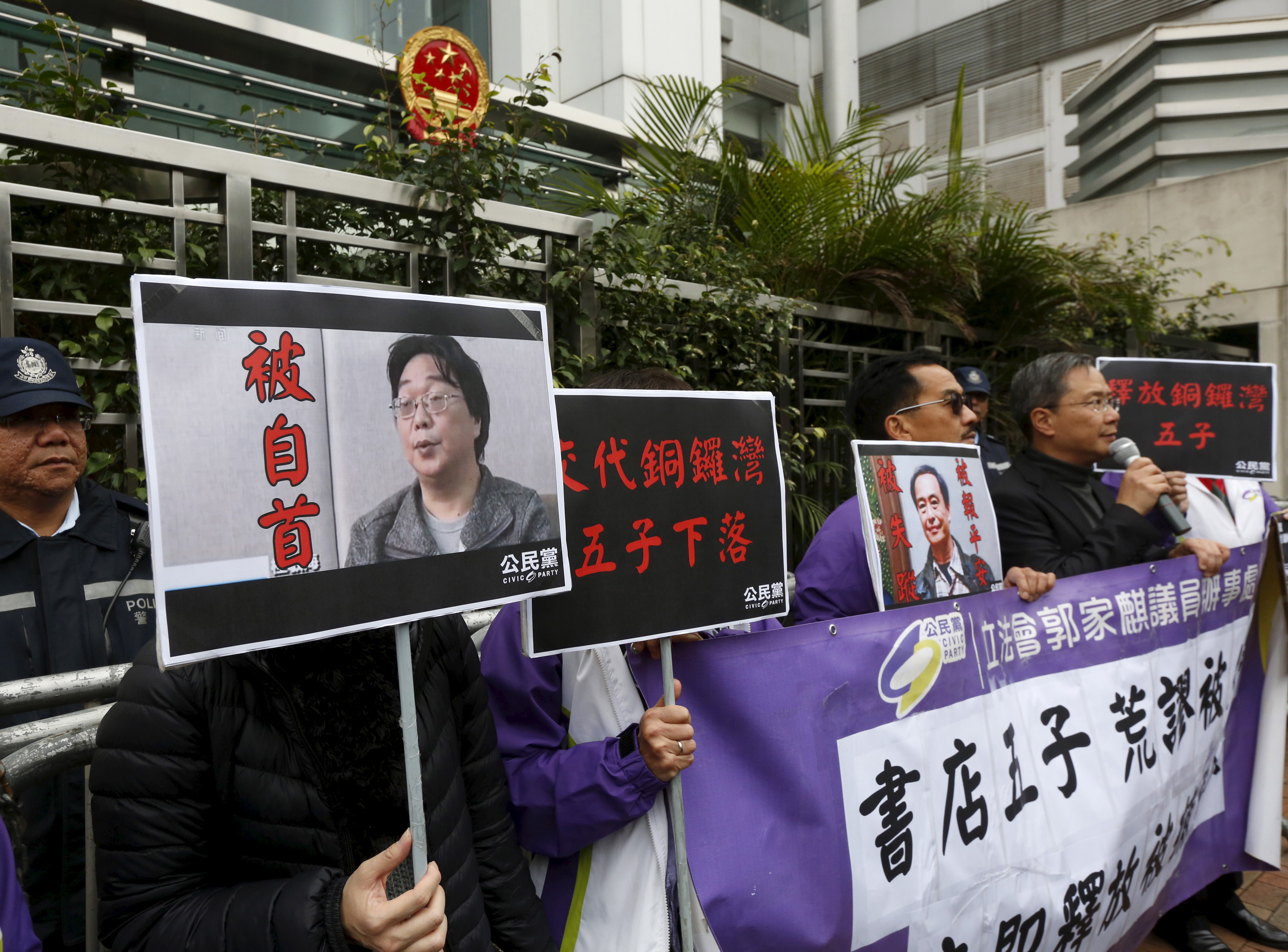 Members from the pro-democracy Civic Party carry a portrait of Gui Minhai (L) and Lee Bo during a protest outside the Chinese Liaison Office in Hong Kong, Jan. 19, 2016. (Bobby Yip—Reuters)